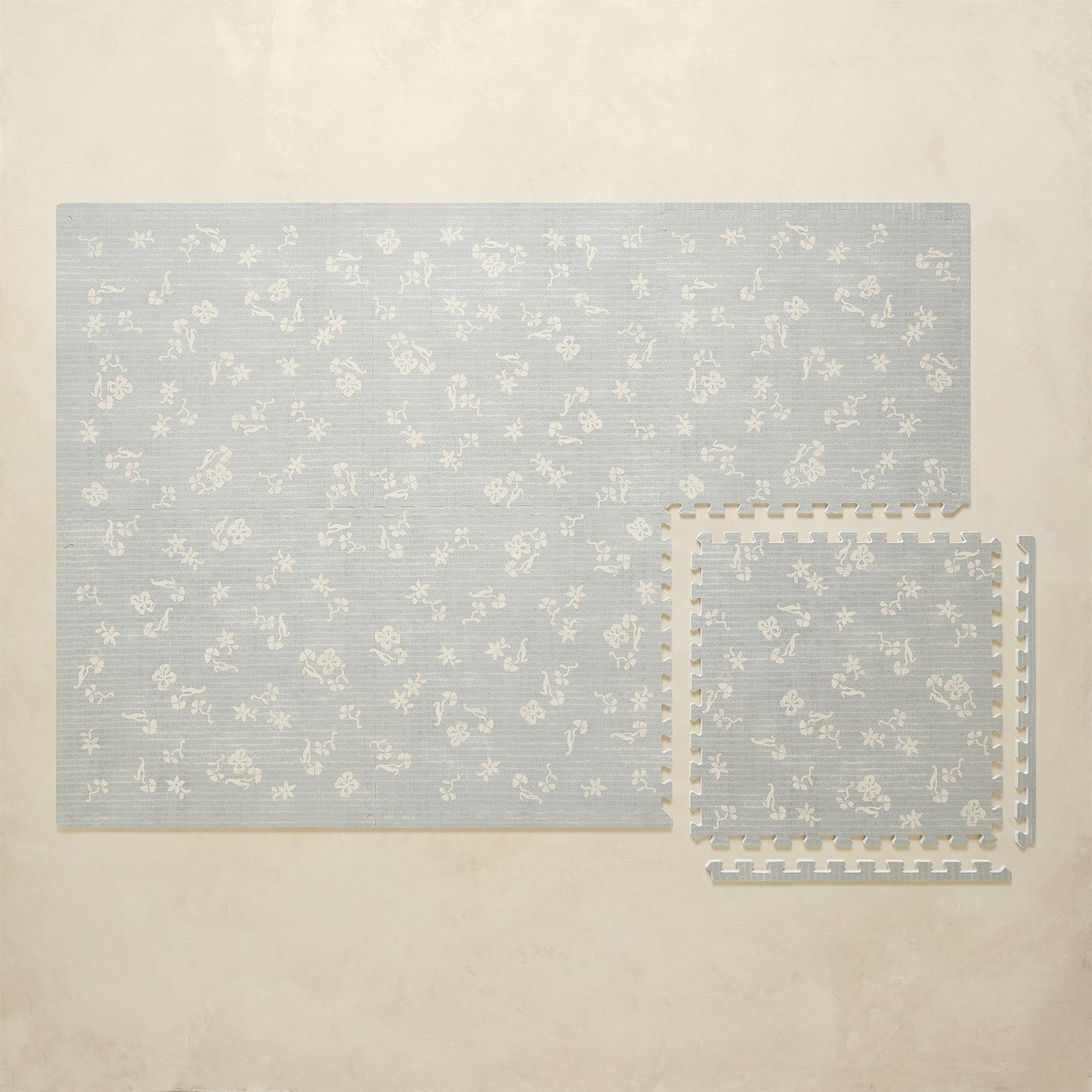 Floral-patterned play mat set on a beige background