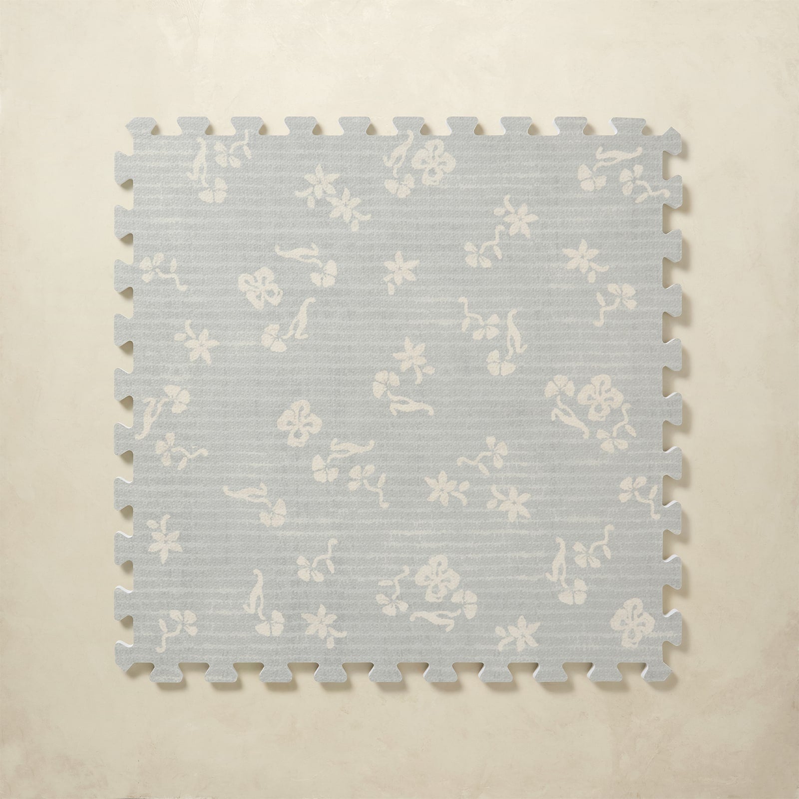 Floral patterned foam puzzle mat on a beige background