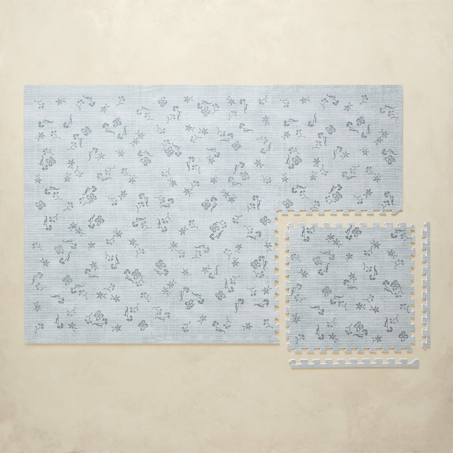 Blue floral-patterned play mat on a beige surface