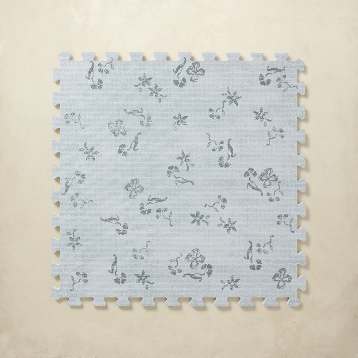 Floral blue patterned foam puzzle tile on a beige background