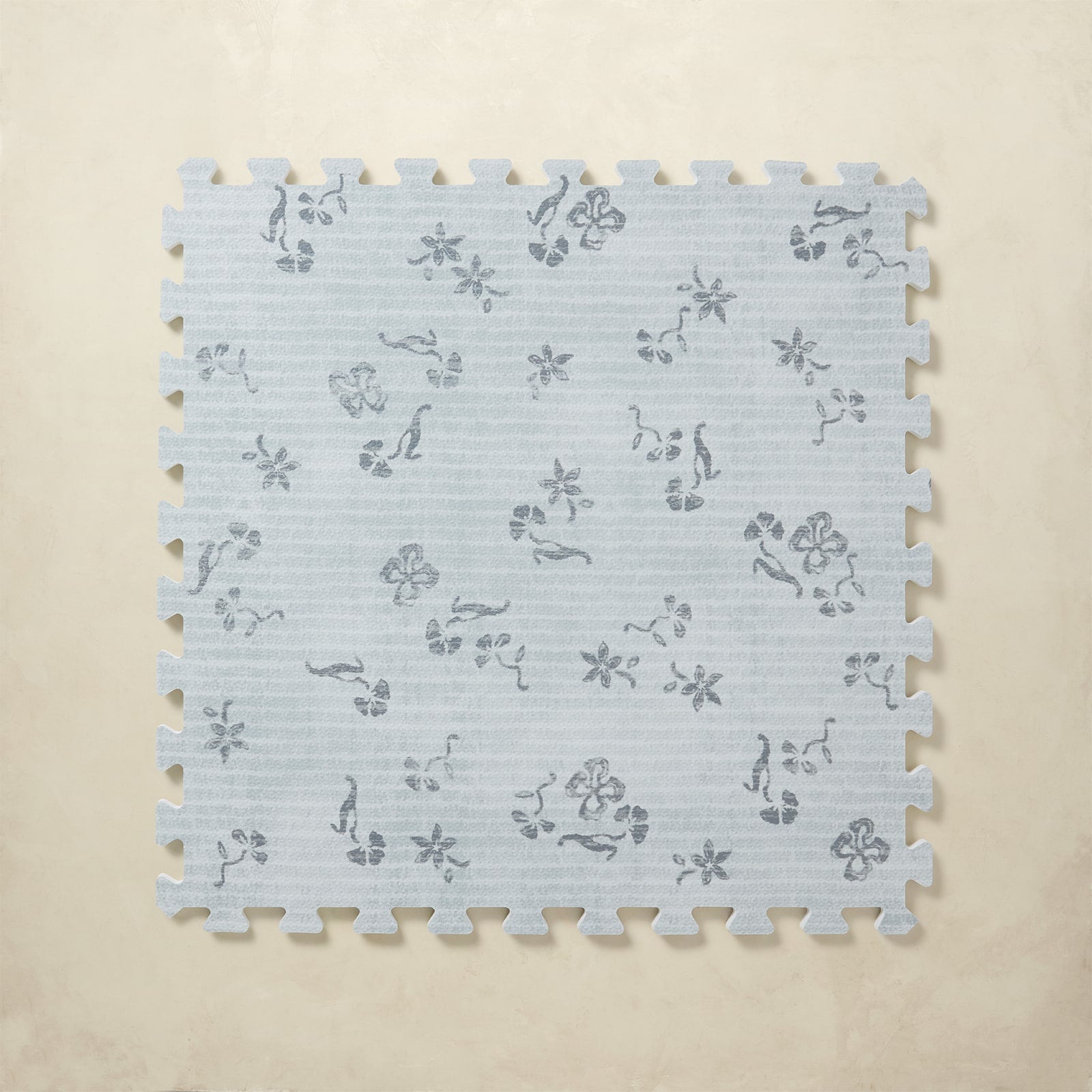 Floral blue patterned foam puzzle tile on a beige background