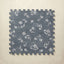 Blue floral patterned interlocking foam tile on a beige background