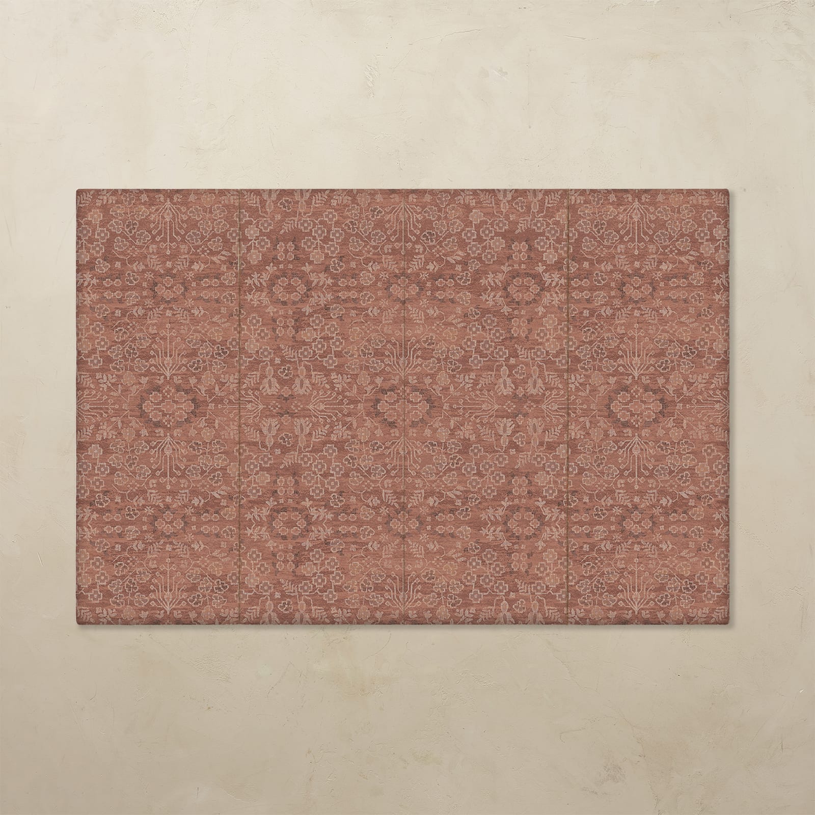 Rectangular area rug with a floral pattern on a beige wall.