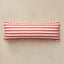 A rectangular lumbar pillow with horizontal red and white stripes and a red-and-white checkered piped edge, shown on a textured beige background.