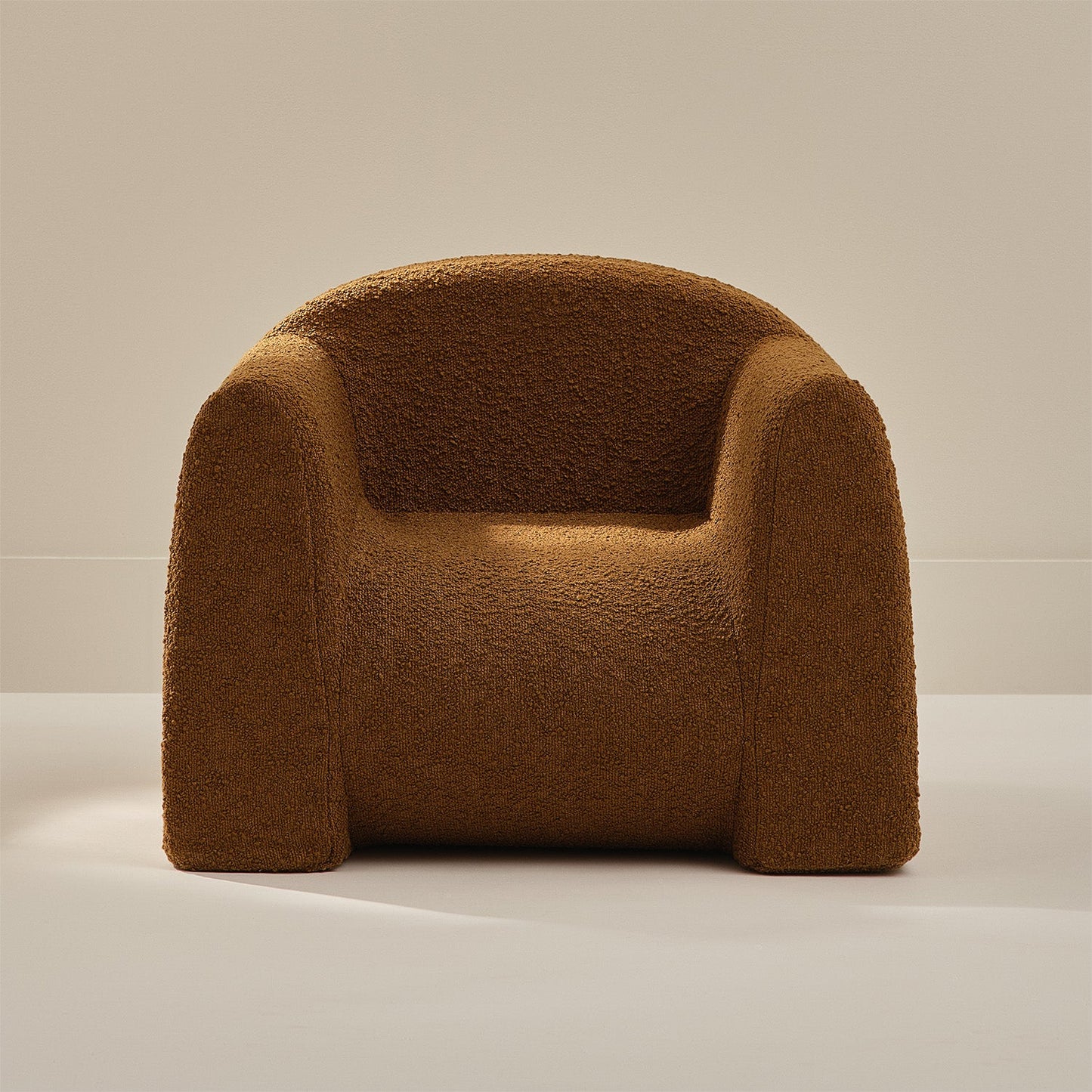 Brown boucle armchair on a neutral background