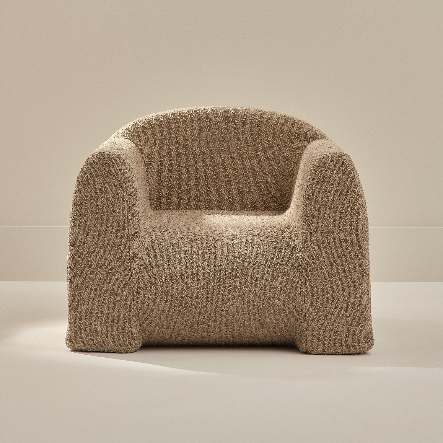 Beige boucle armchair on a neutral background