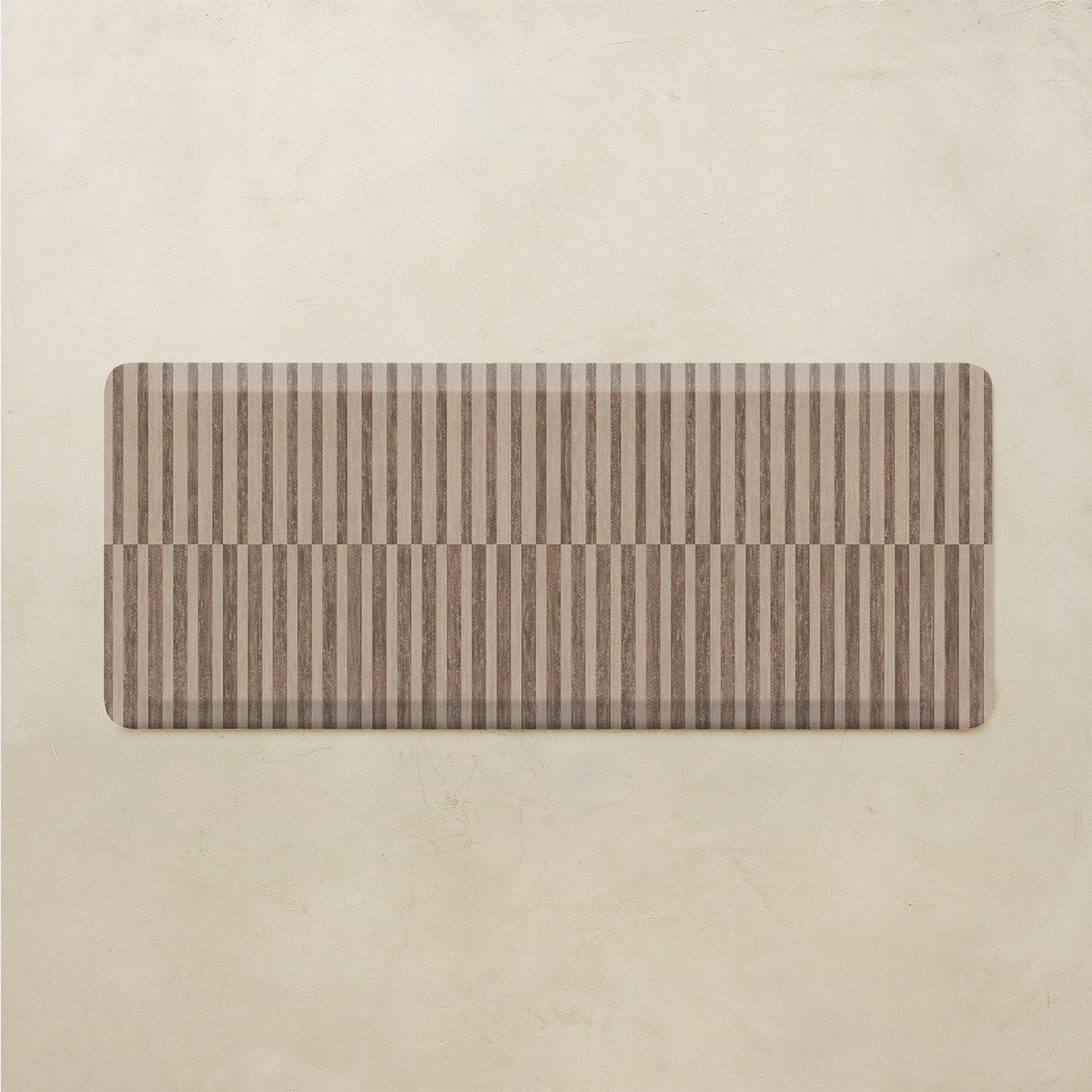 Rectangular kitchen mat with brown and beige stripes on a beige background