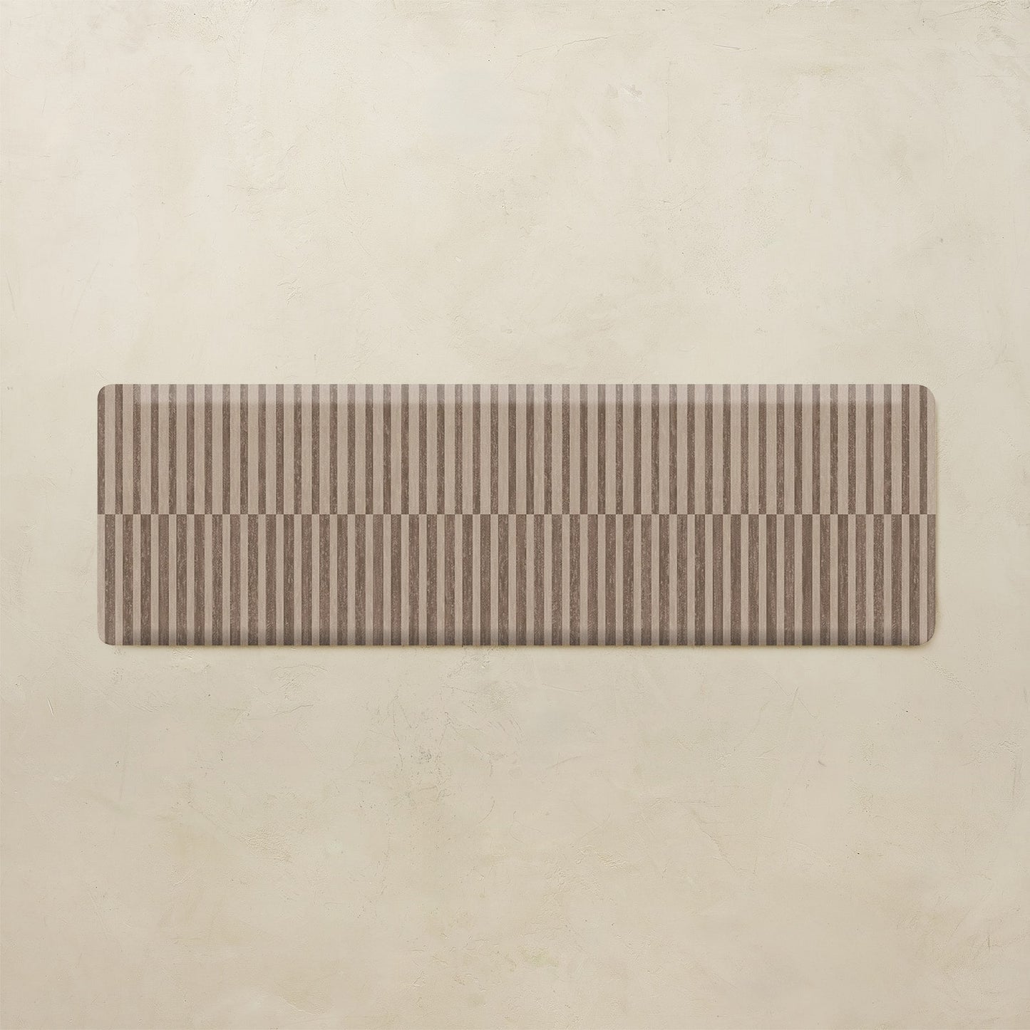Rectangular brown striped kitchen mat on a beige background