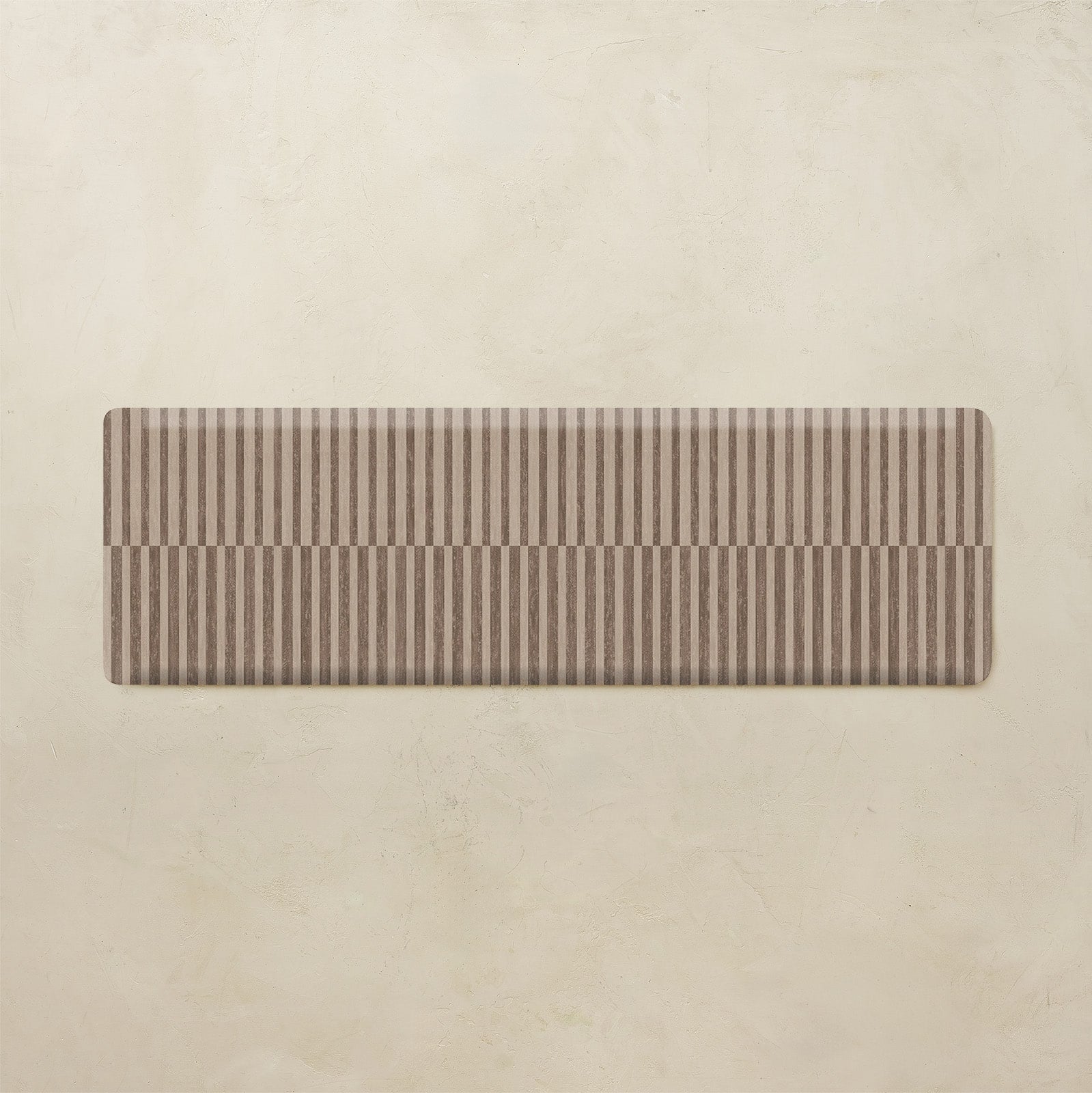 Rectangular brown striped kitchen mat on a beige background