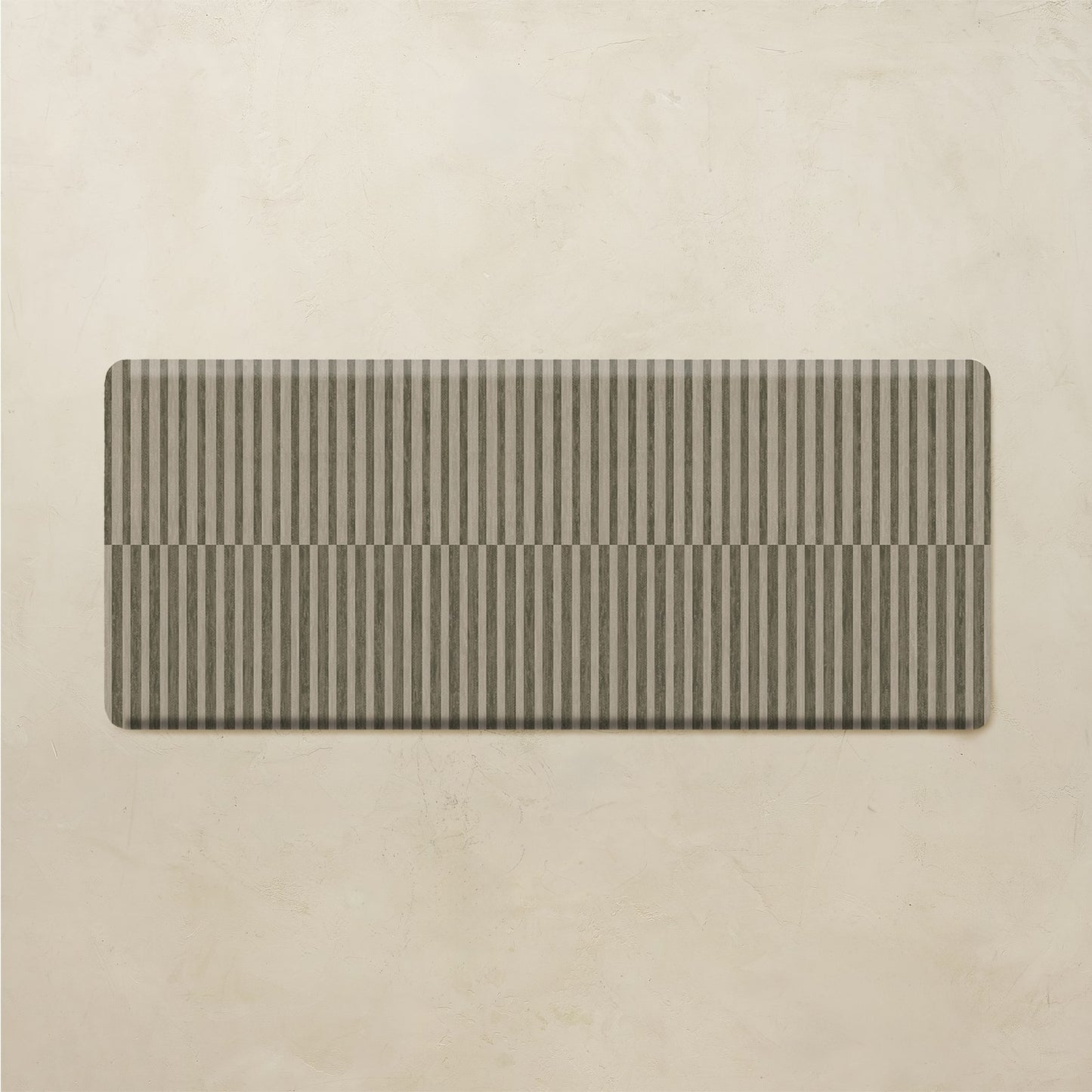 Rectangular striped kitchen mat on a beige background