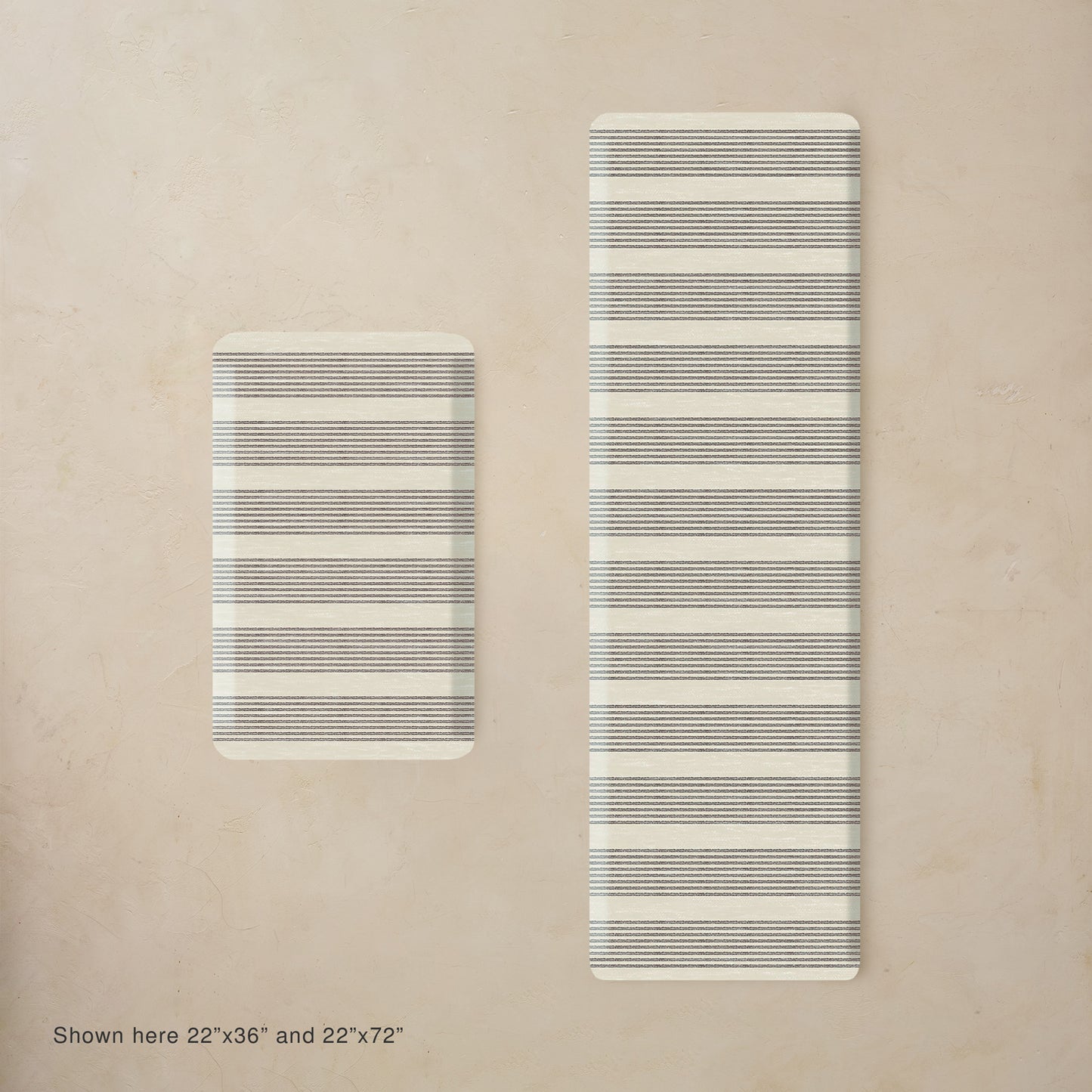 Two striped black and white mats on a beige background, one smaller than the other.