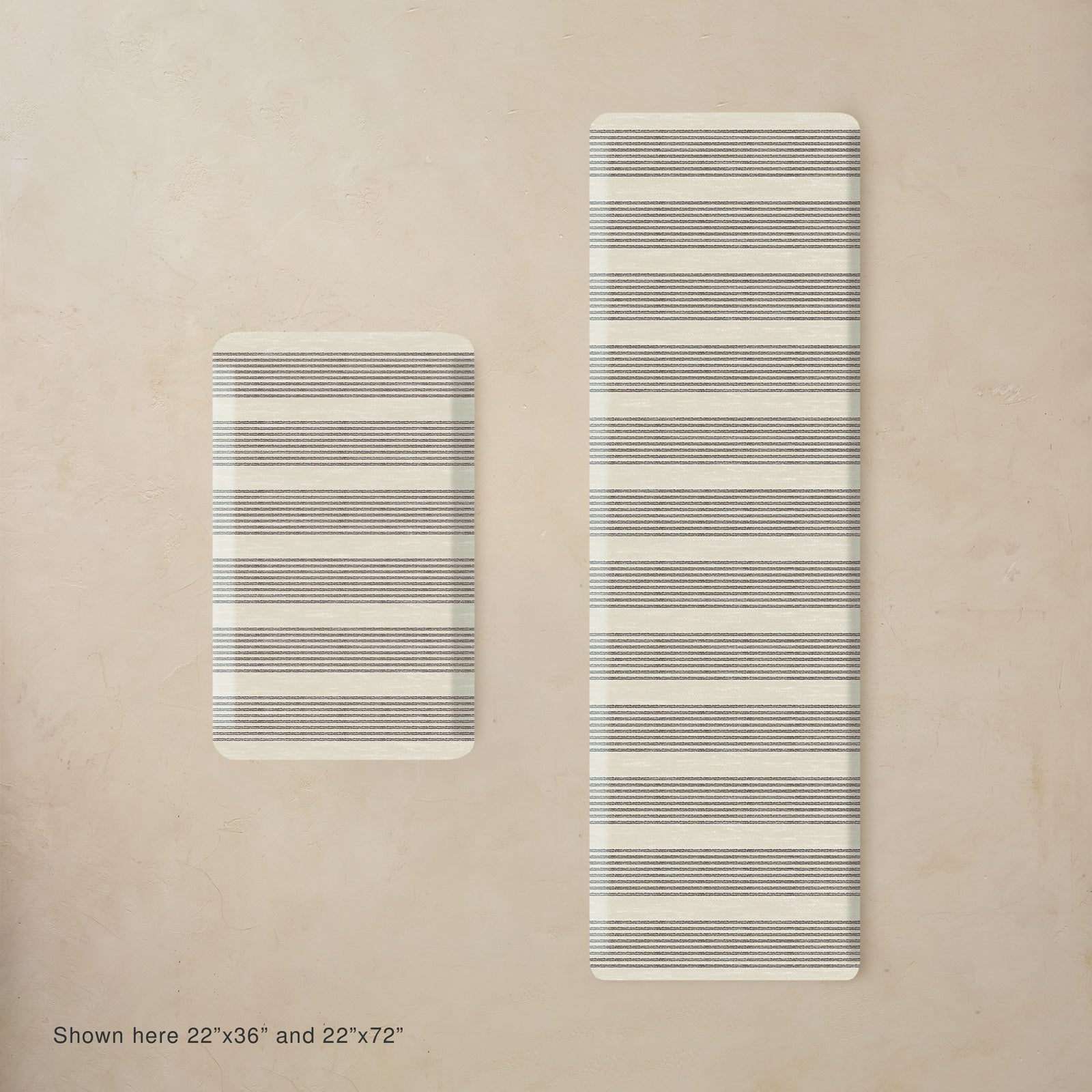 Two striped black and white mats on a beige background, one smaller than the other.
