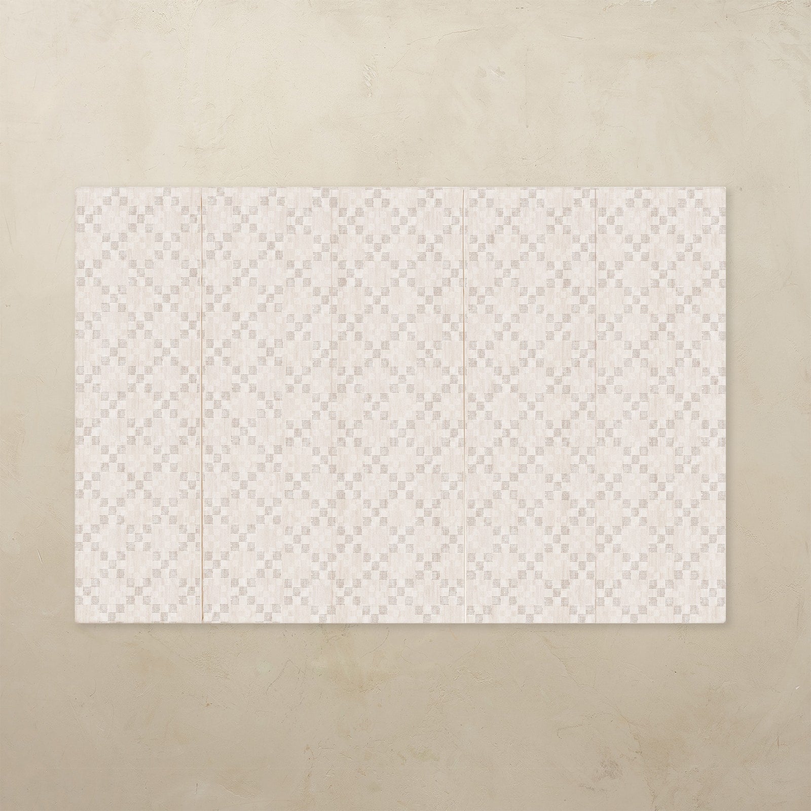 White patterned play mat on a beige background