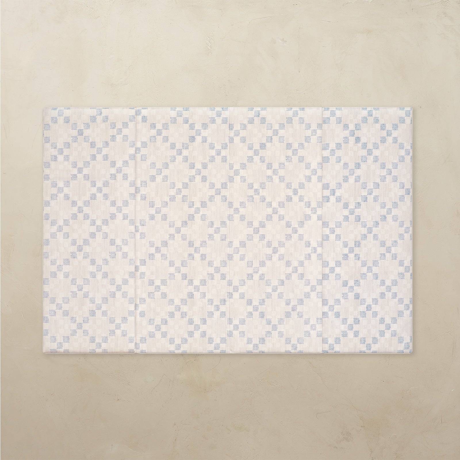 Patterned tumbling mat with blue and white design on a beige background