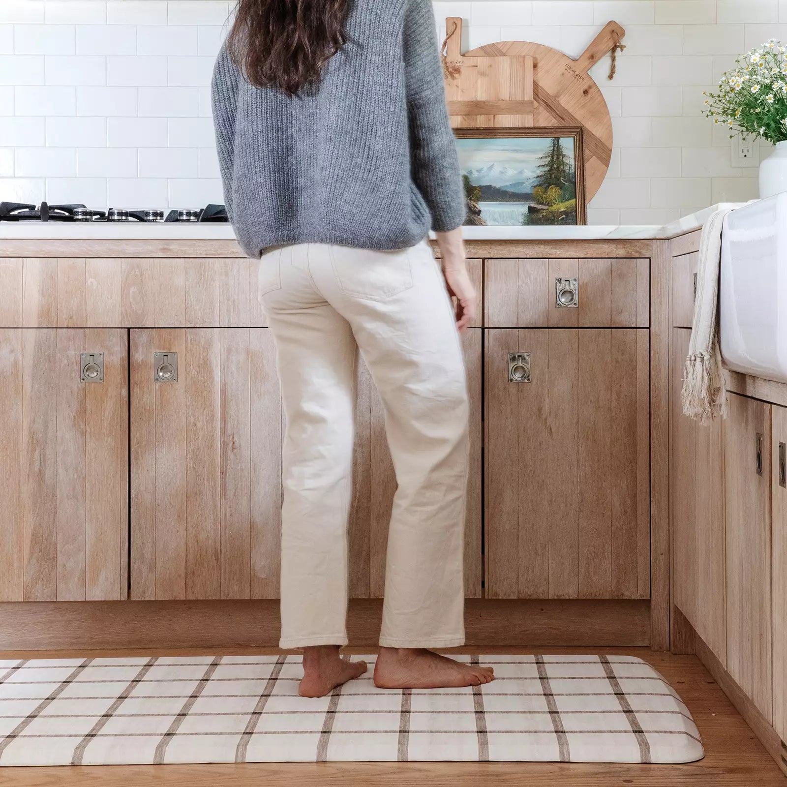 Windowpane neutral brown and white grid pattern standing mat. Shown in kitchen with woman cooking at counter