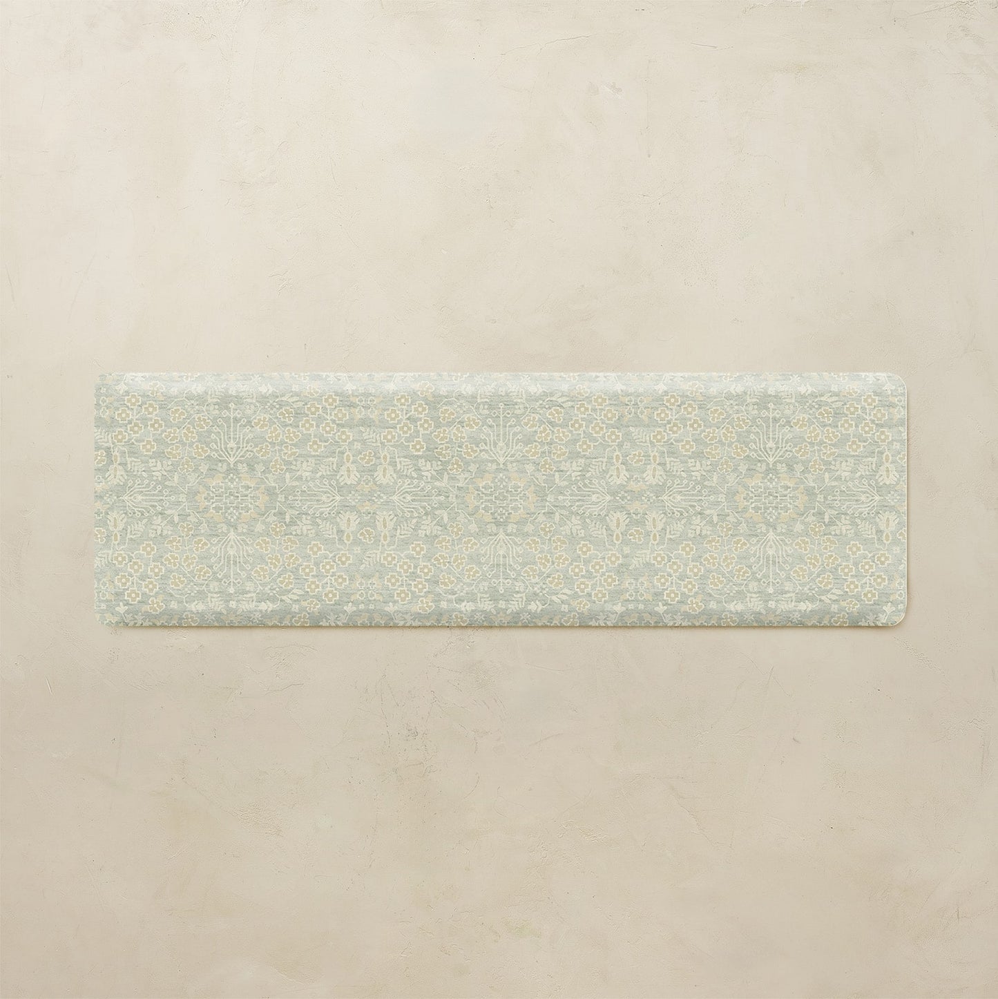 Rectangular green mat with floral pattern on a beige background