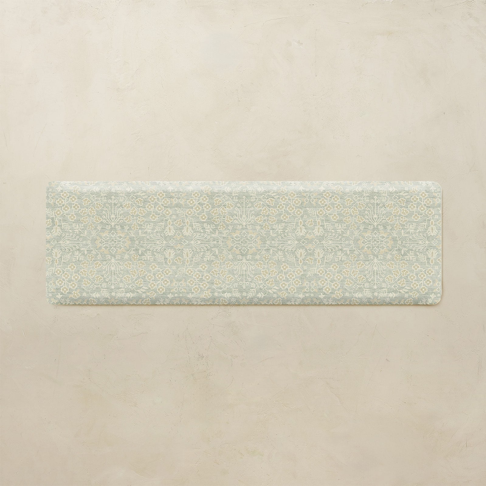 Rectangular green mat with floral pattern on a beige background