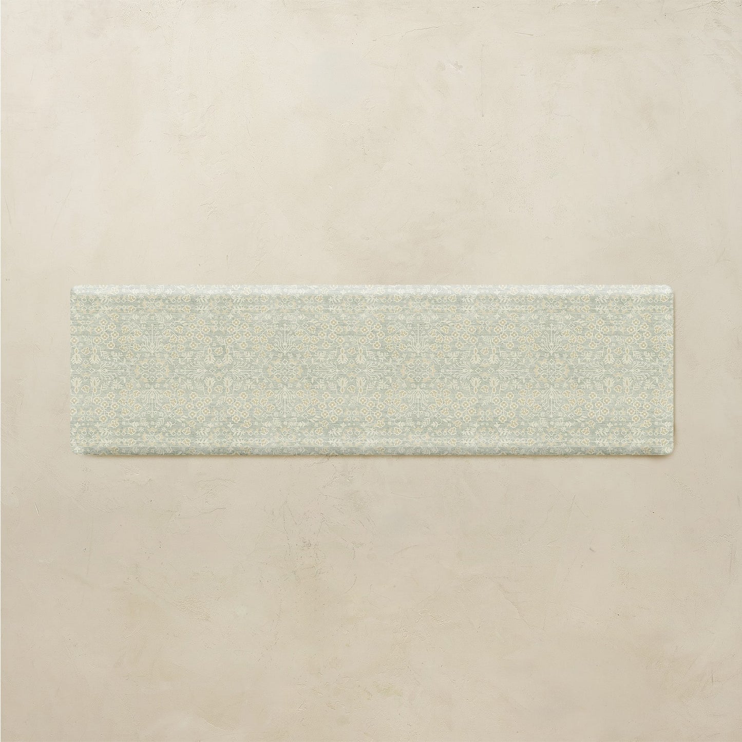 Rectangular floral kitchen mat on a beige background