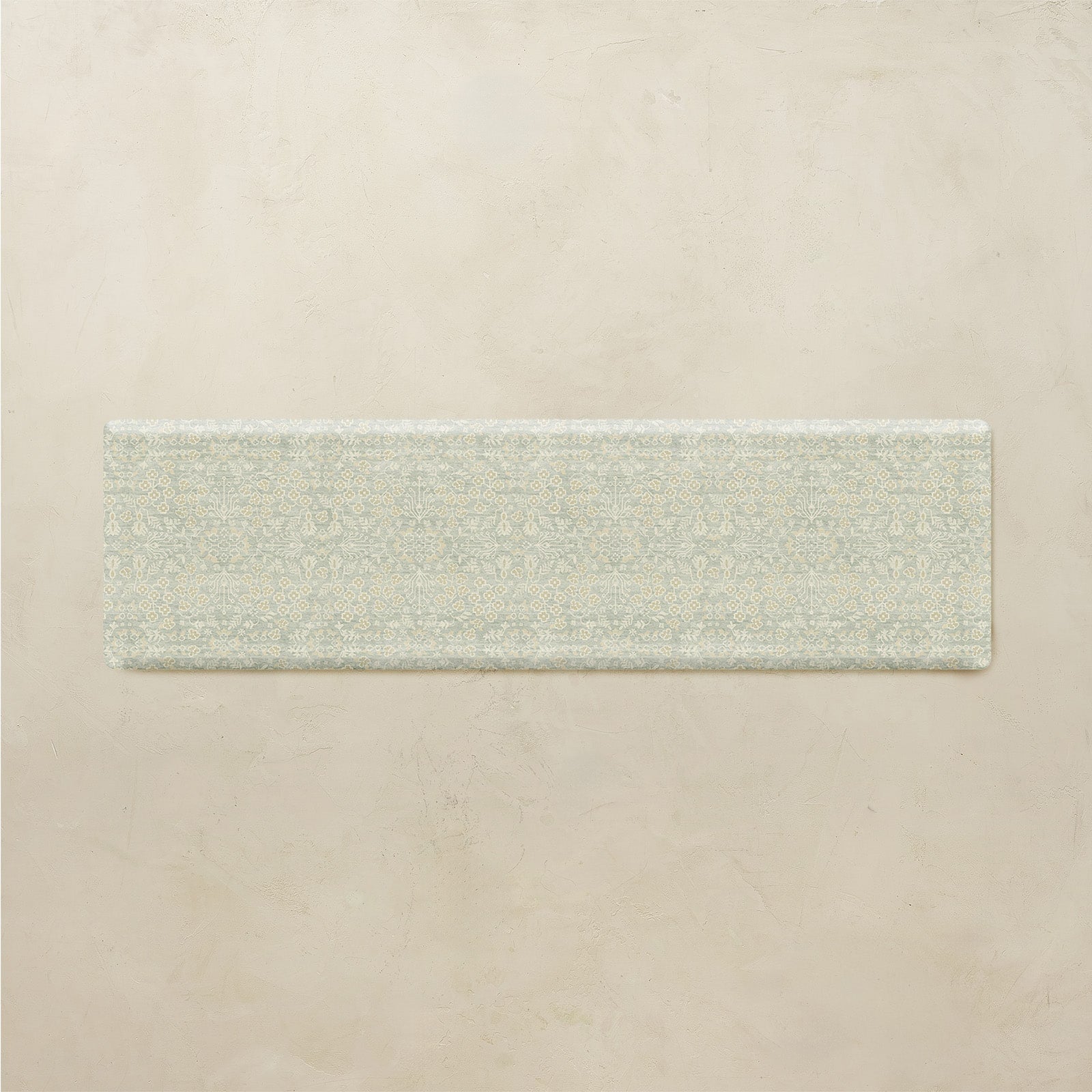 Rectangular floral kitchen mat on a beige background