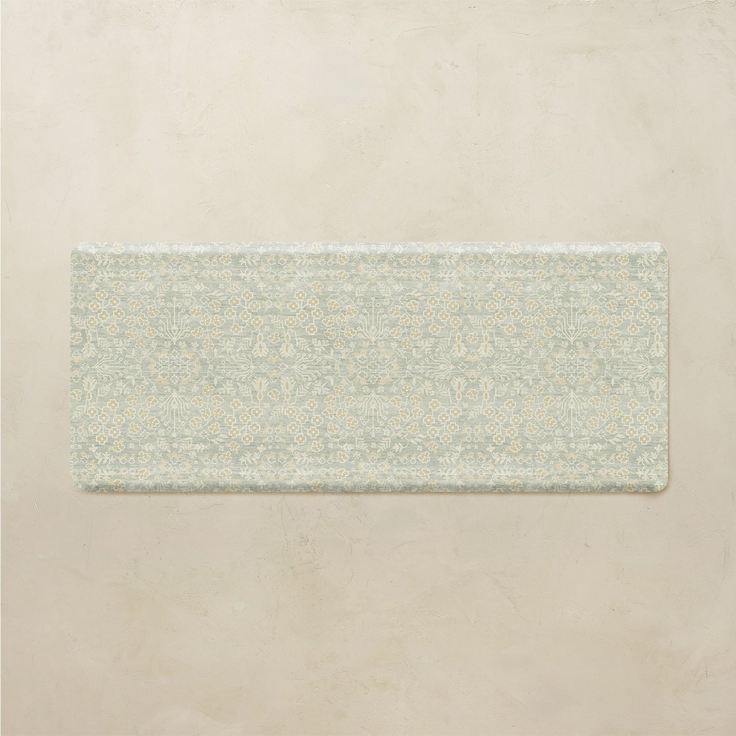 Rectangular green kitchen mat with a subtle pattern on a beige background