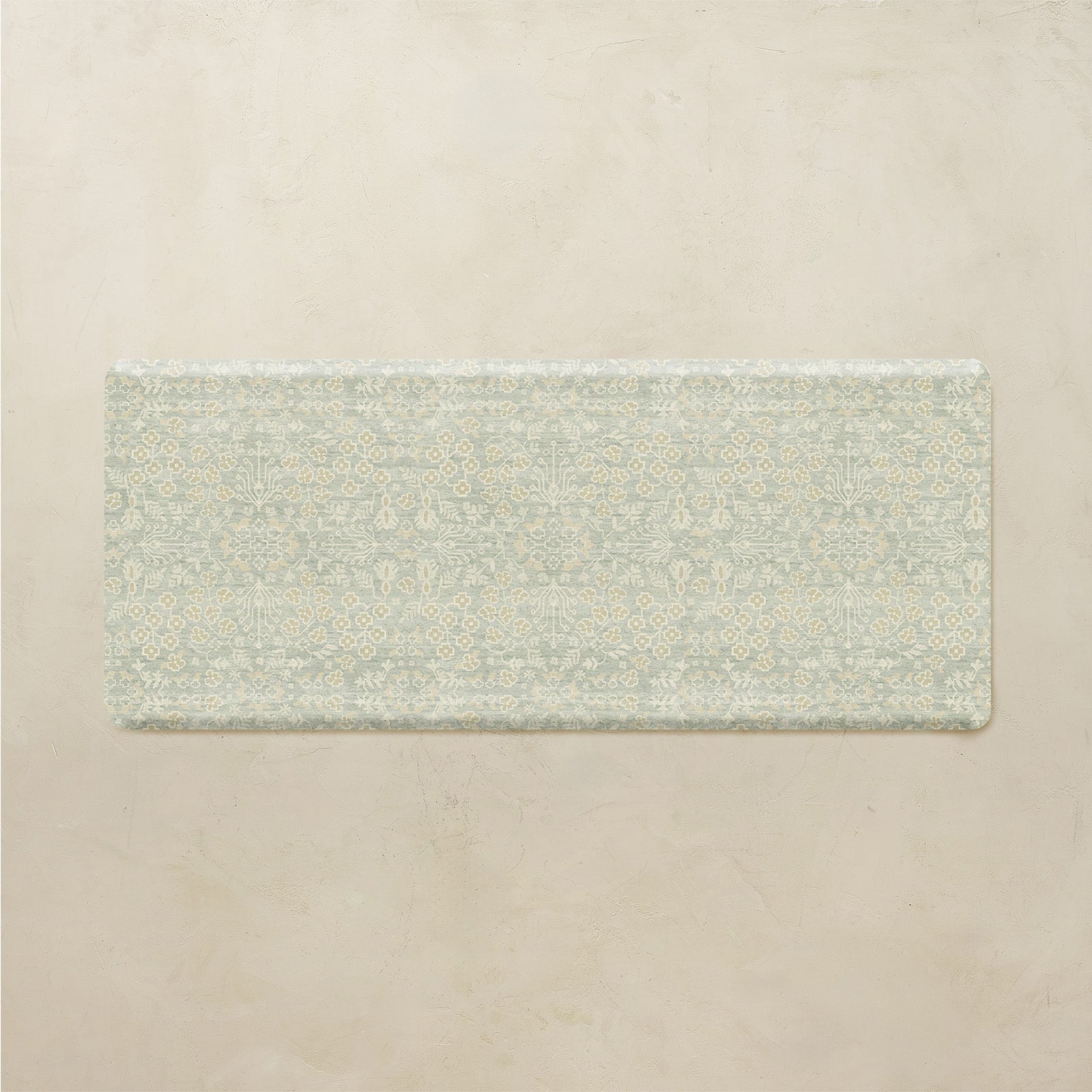 Rectangular green kitchen mat with a subtle pattern on a beige background