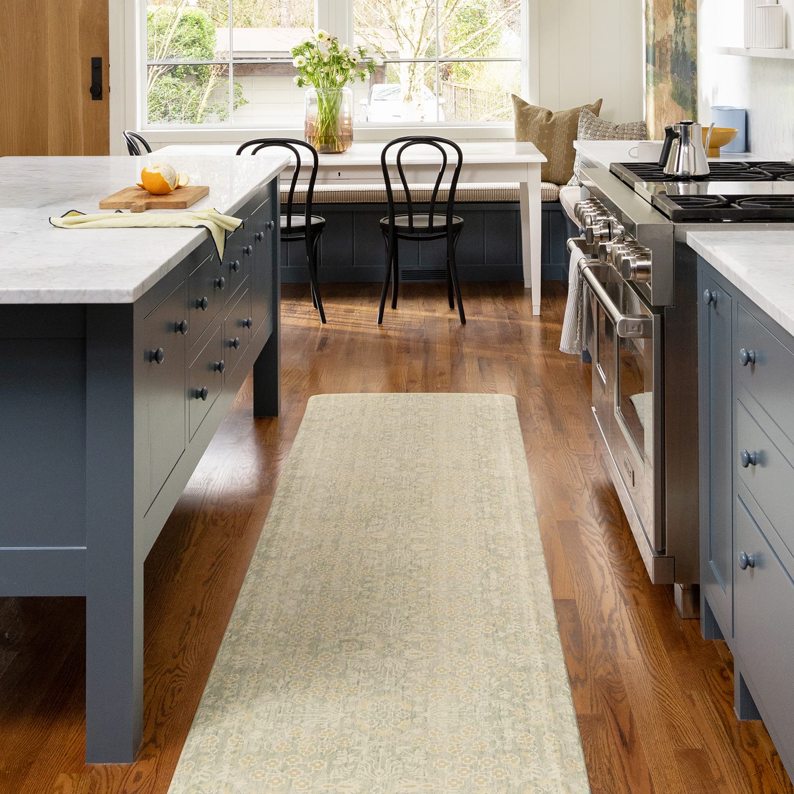 Blue kitchen with wooden floors and light green mat in between the counters.