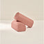 Two pink cylindrical armrests on a beige background