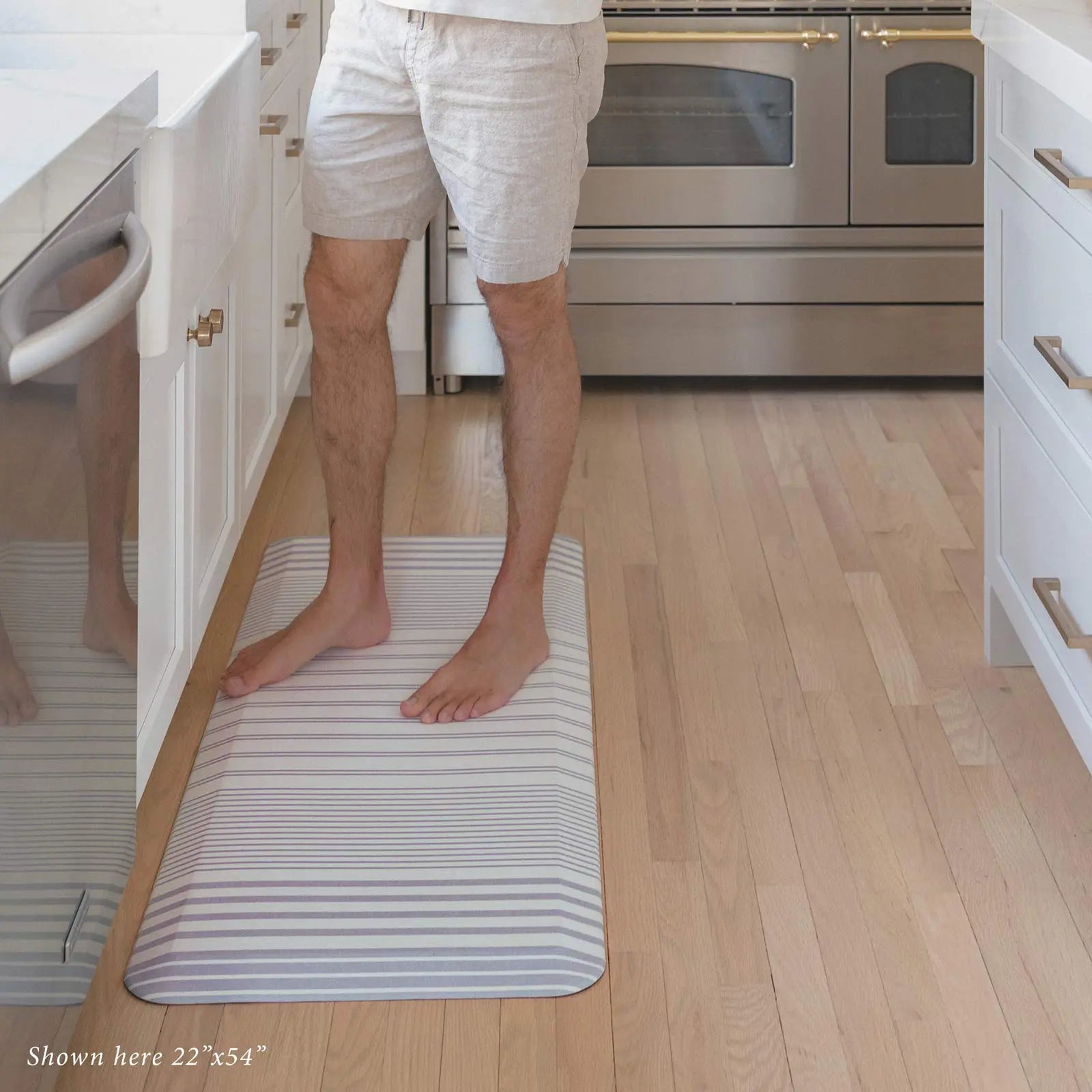 Nantucket Coastal Minimal Blue Ivory Stripe Standing Mat shown with man standing at the kitchen counter on the mat in size 22x54