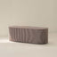 Rectangular ottoman with a ribbed texture on a light background