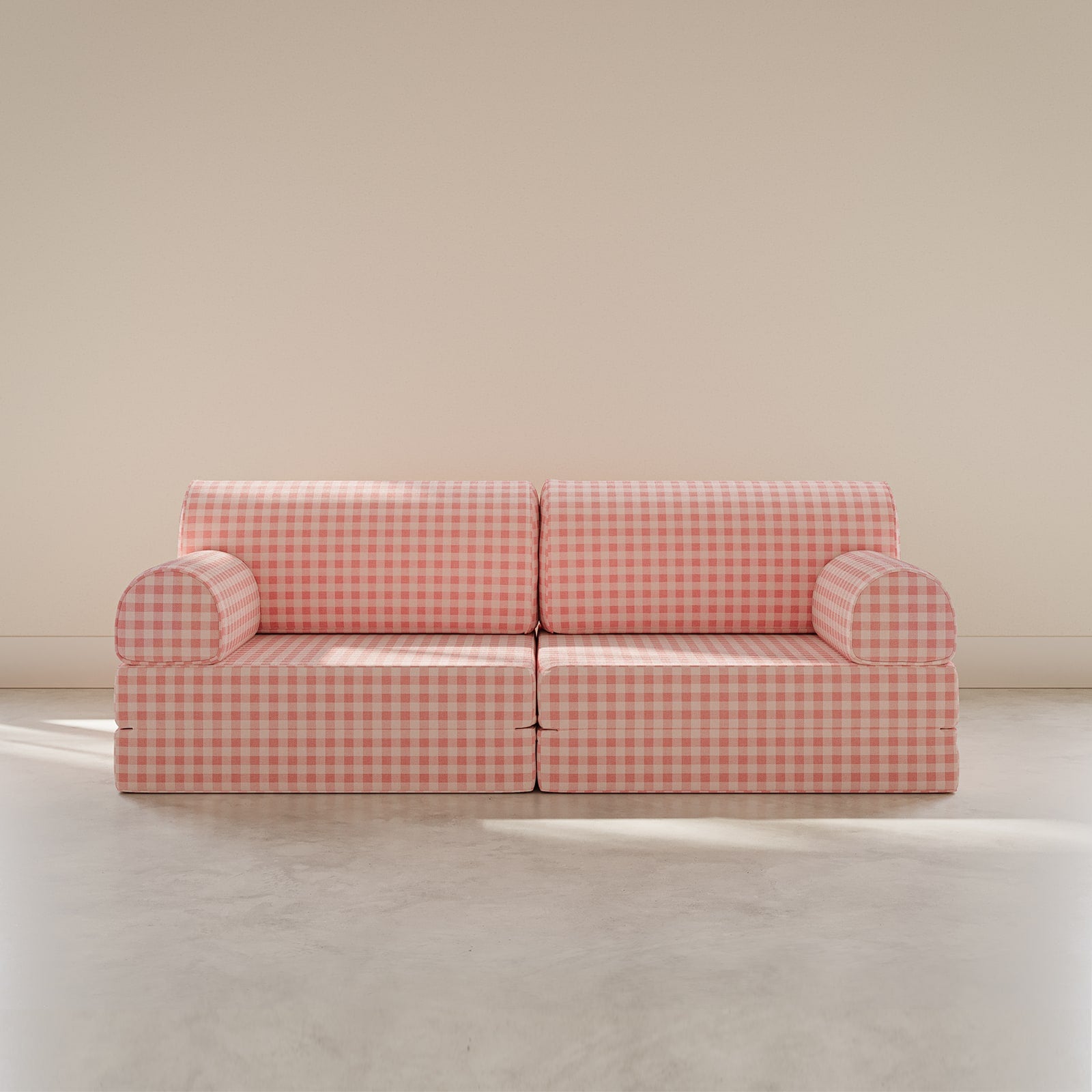 Pink checkered sofa on a beige floor with a beige wall background