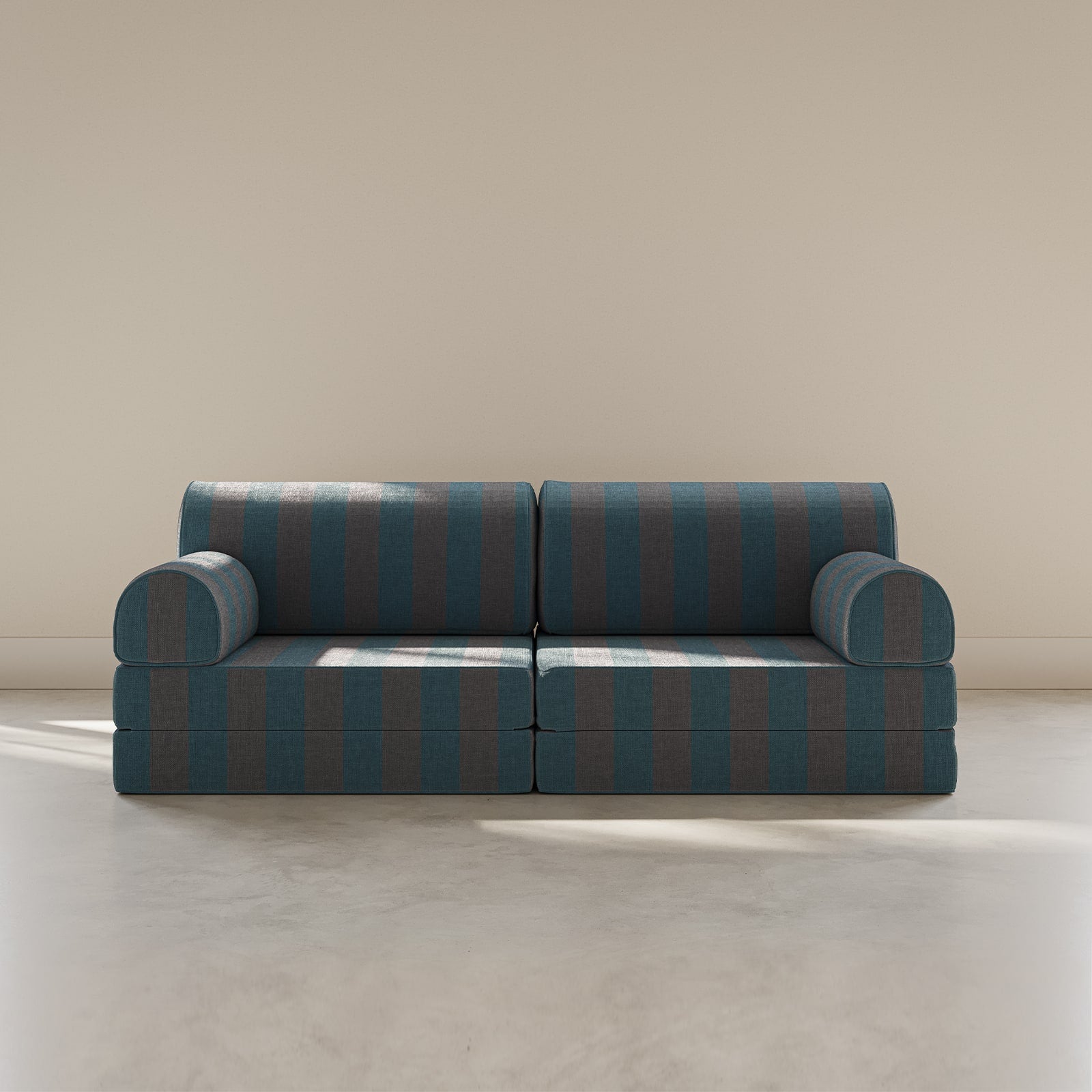 Blue and green striped sofa on a beige floor with a neutral wall background