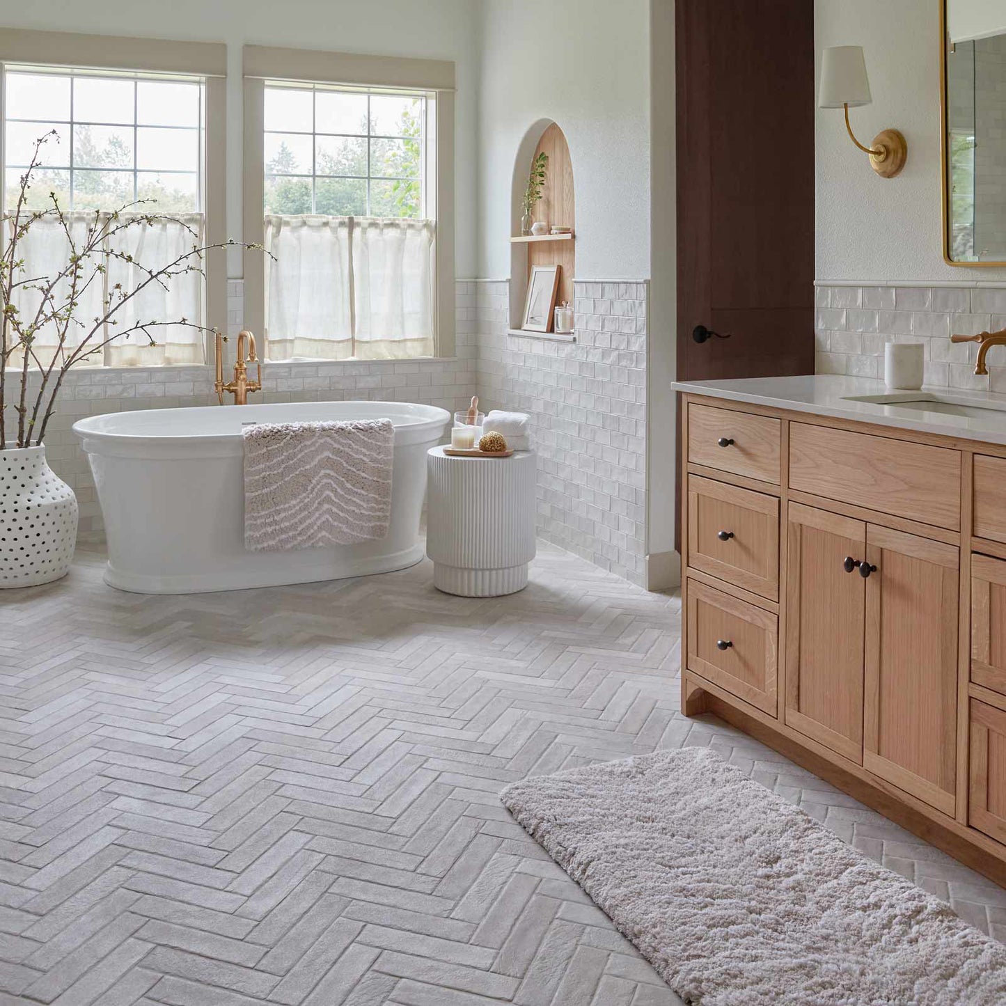 Zelda shell neutral zebra print bath rug shown in size 21x34 in front of a bath tub and in size 21x58 in front of a double vanity