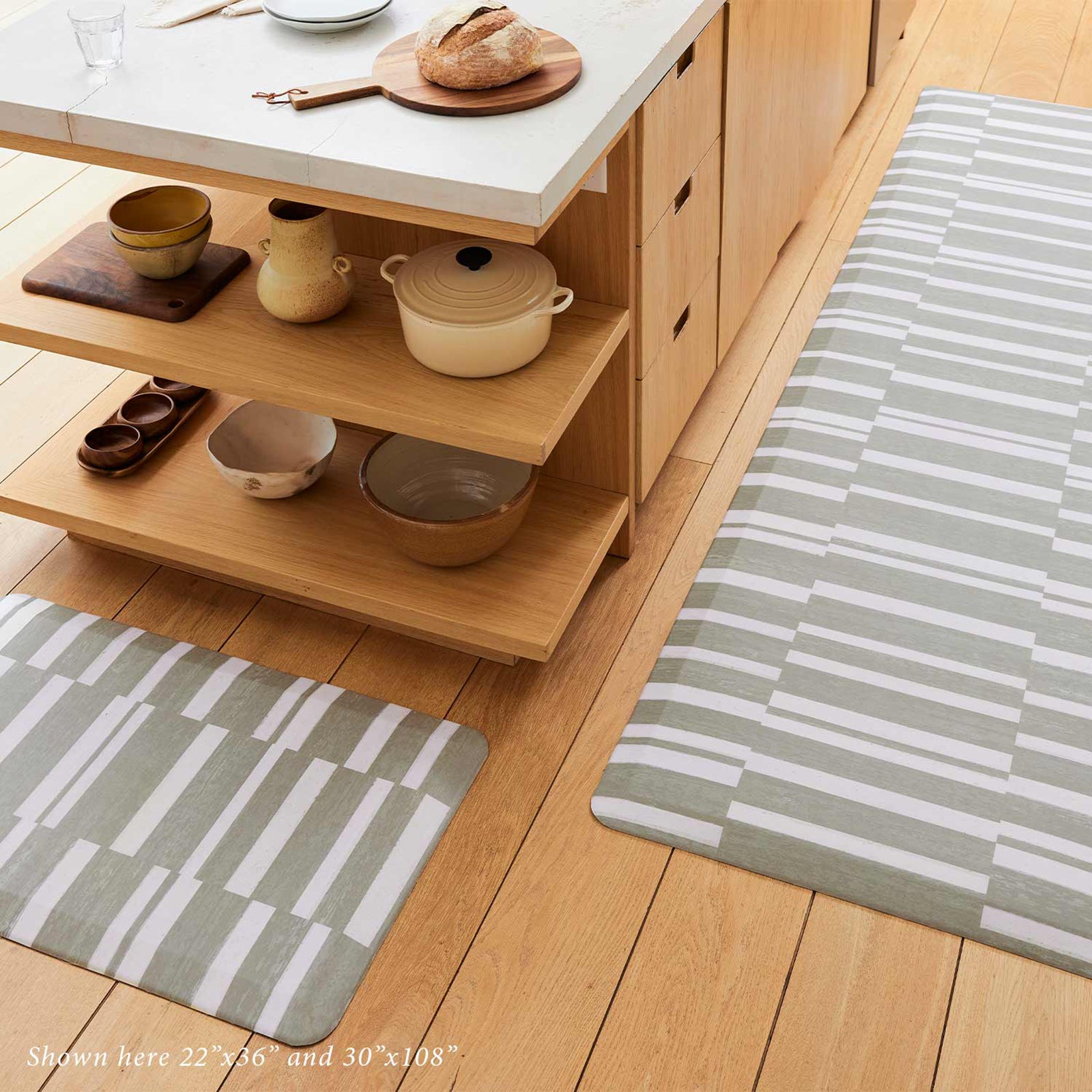 sutton stripe basil olive green and white inverted stripe standing mat shown in light wood toned kitchen with sizes 22x36 and 30x108 shown around the island