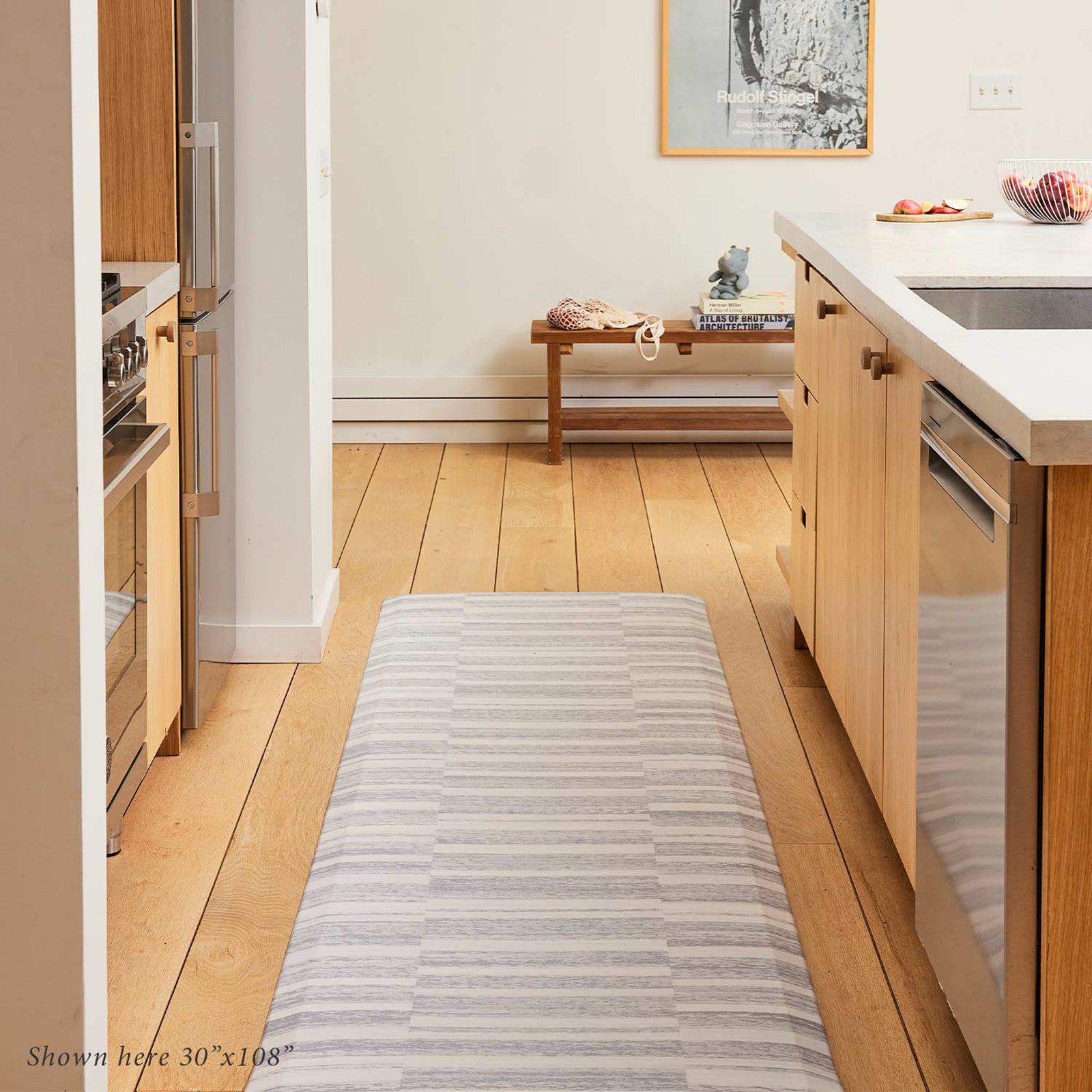 Sutton stripe heather gray and white inverted stripe standing mat shown in light wood tone kitchen with size 30x108 on the floor between the counter and island