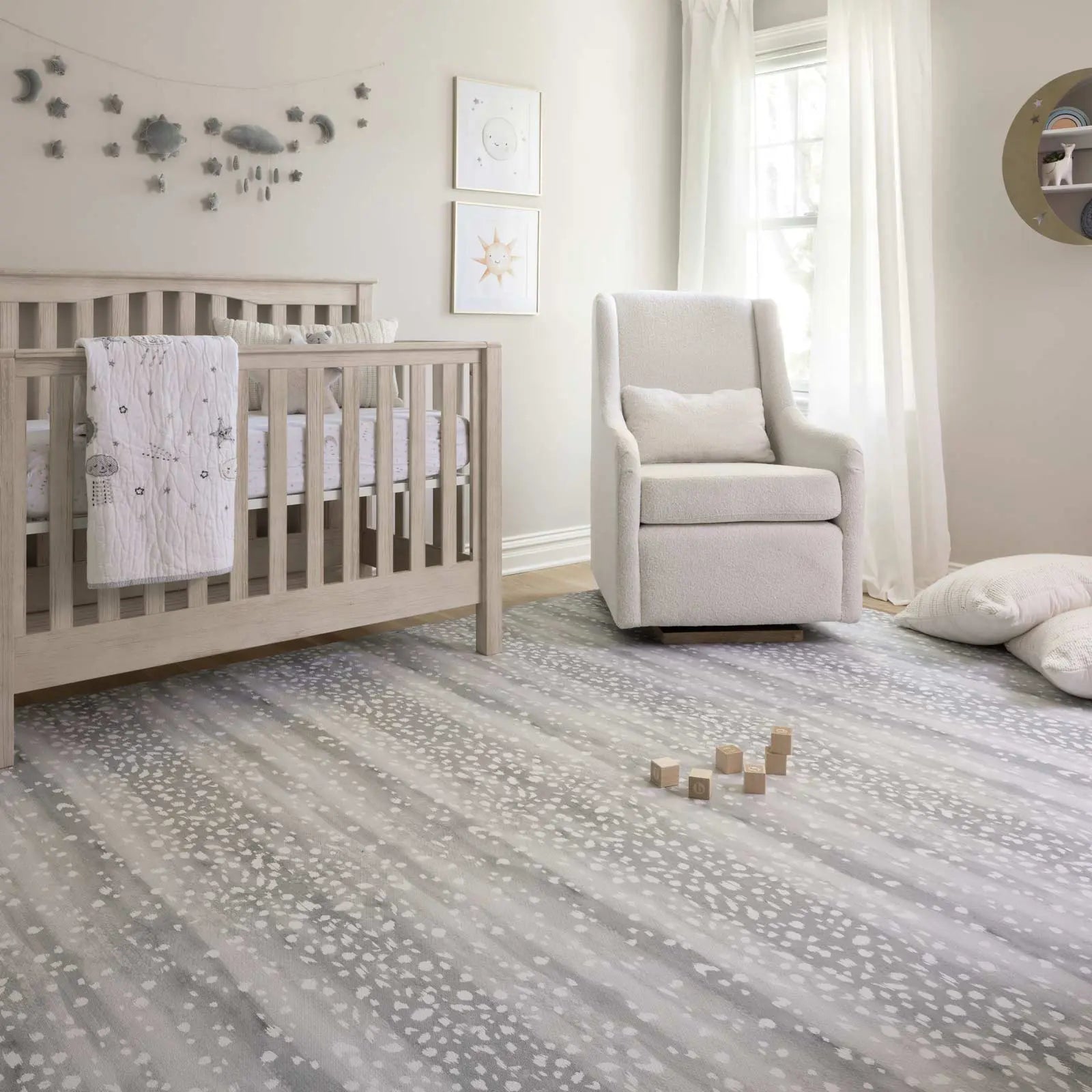 Fawn silver gray animal print play mat shown in nursery with crib, rocker, and blocks on the mat.