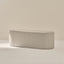 Round ottoman with grid pattern on a neutral background