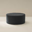 A round navy blue ottoman with a textured boucle fabric cover, presented against a neutral background.