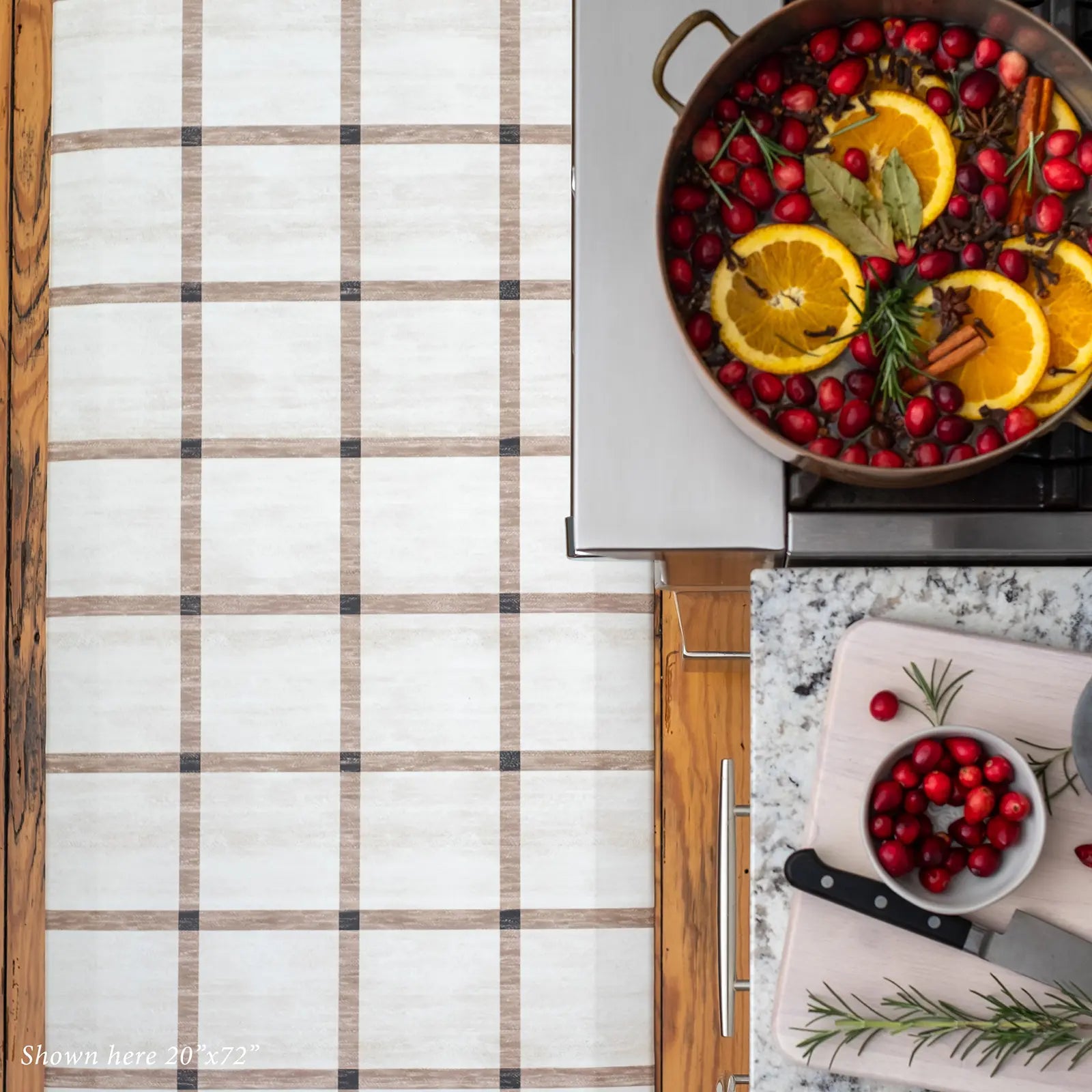 Brown and white neutral grid pattern kitchen mat shown in size 20x72 from above in front of stove with cranberry and orange stovetop potpourri 