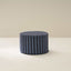 A cylindrical soft furniture ottoman with beige and white checkered fabric upholstery.