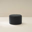 A beige upholstered ottoman with a round shape placed on a white background.