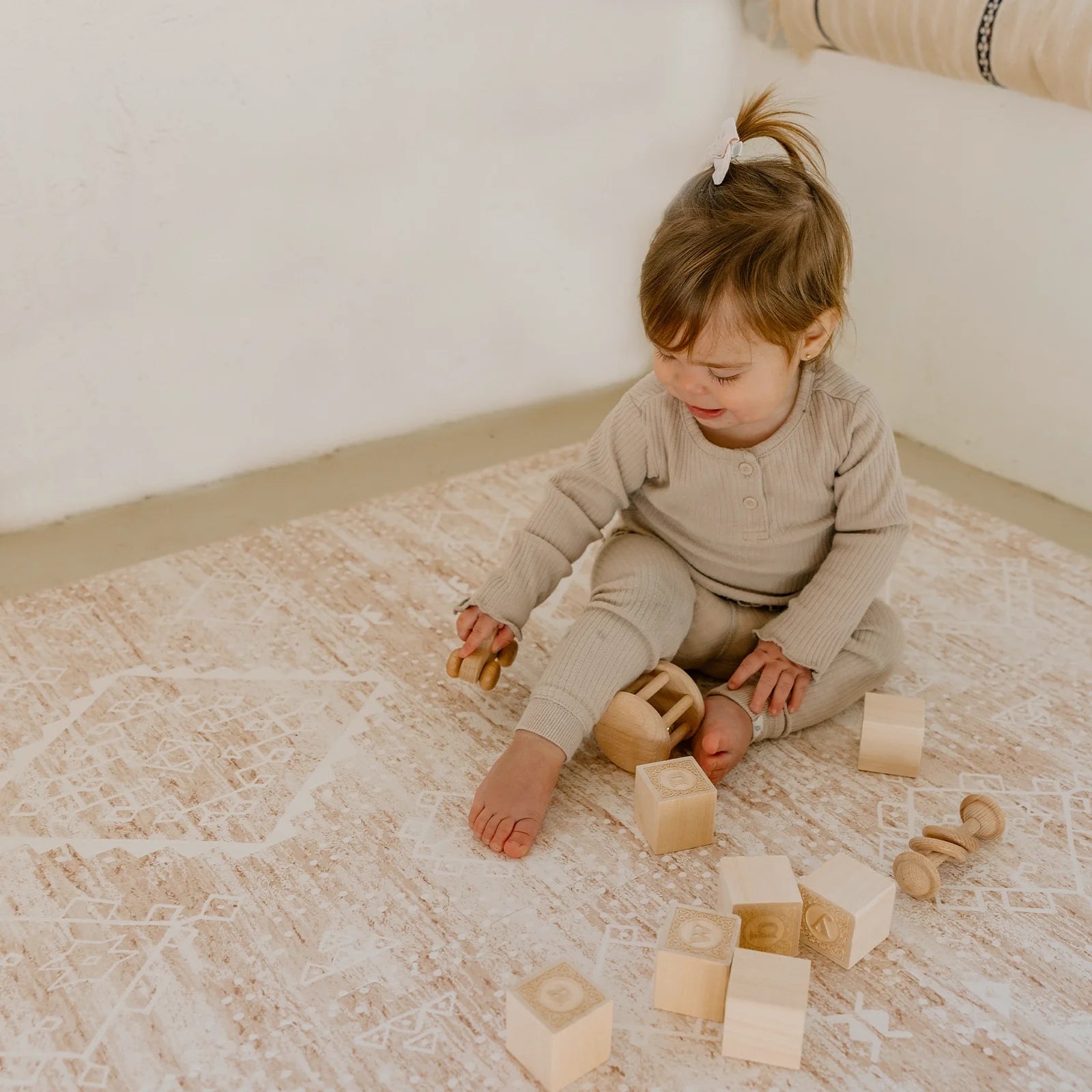 Ula Sienna neutral pink minimal boho pattern play mat with baby girl playing with wooden blocks and toys