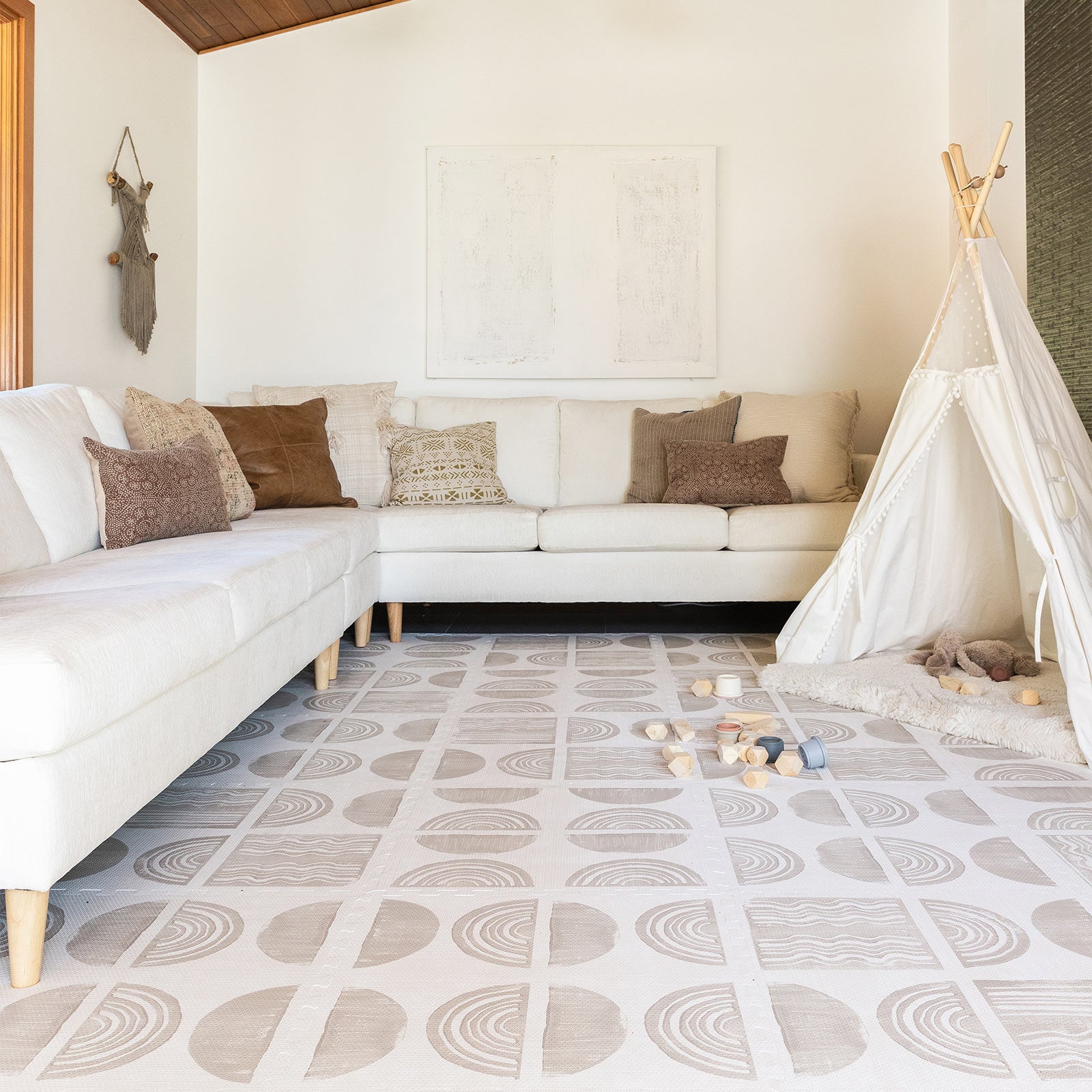 Ada modern minimalist baby play mat in Pebble taupe and off white. Shown in living room with toys.