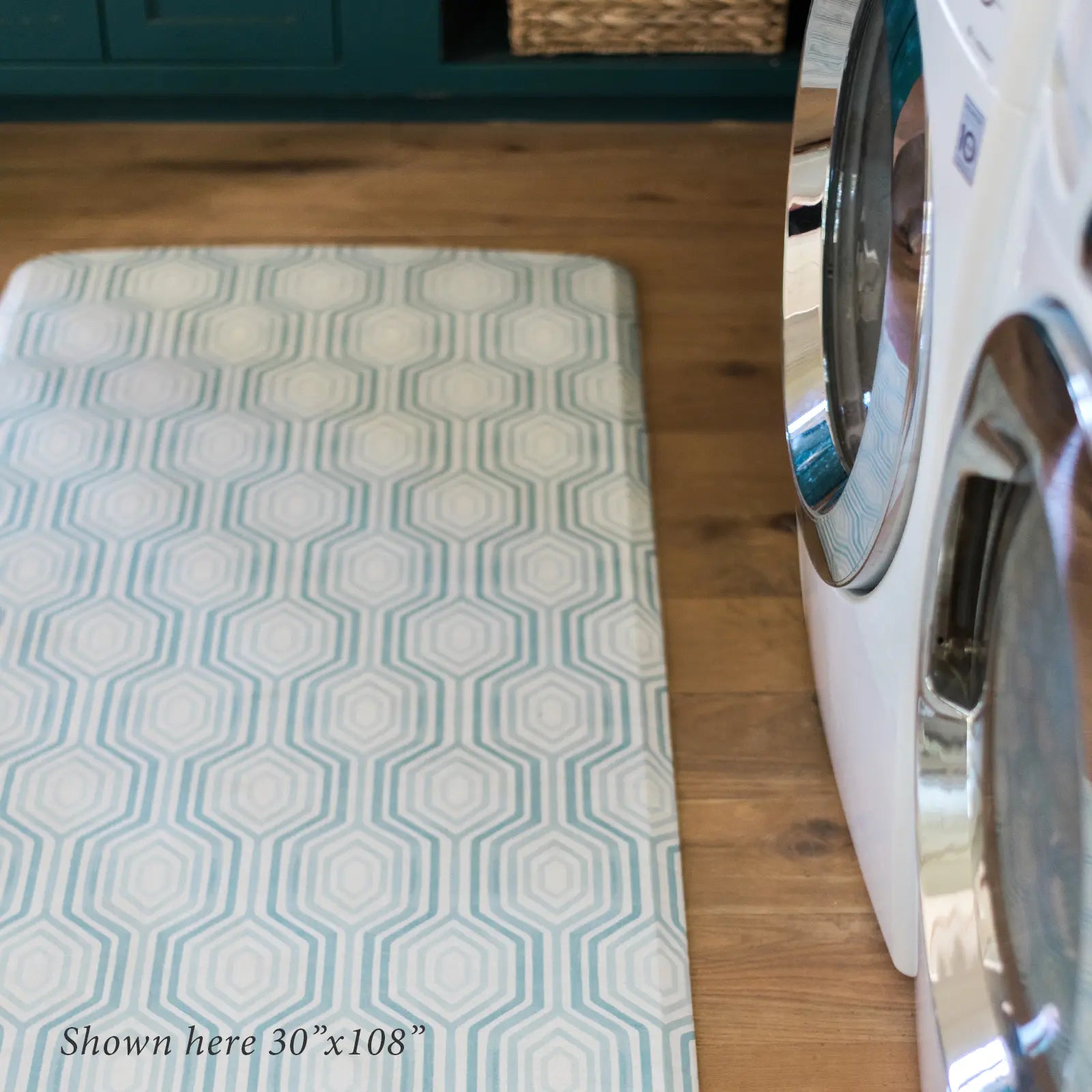 Blake waves blue and white mod preppy geometric print kitchen mat shown in size 30x108 in front of washer and dryer in laundry room.