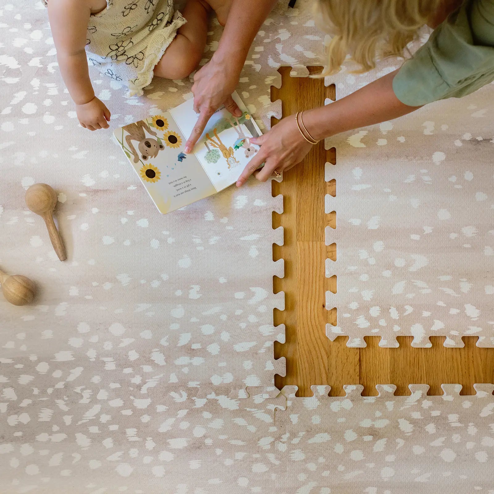 Fawn neutral beige animal print baby play mat. Shown from above with Mom and baby reading with 1 tile exposed.