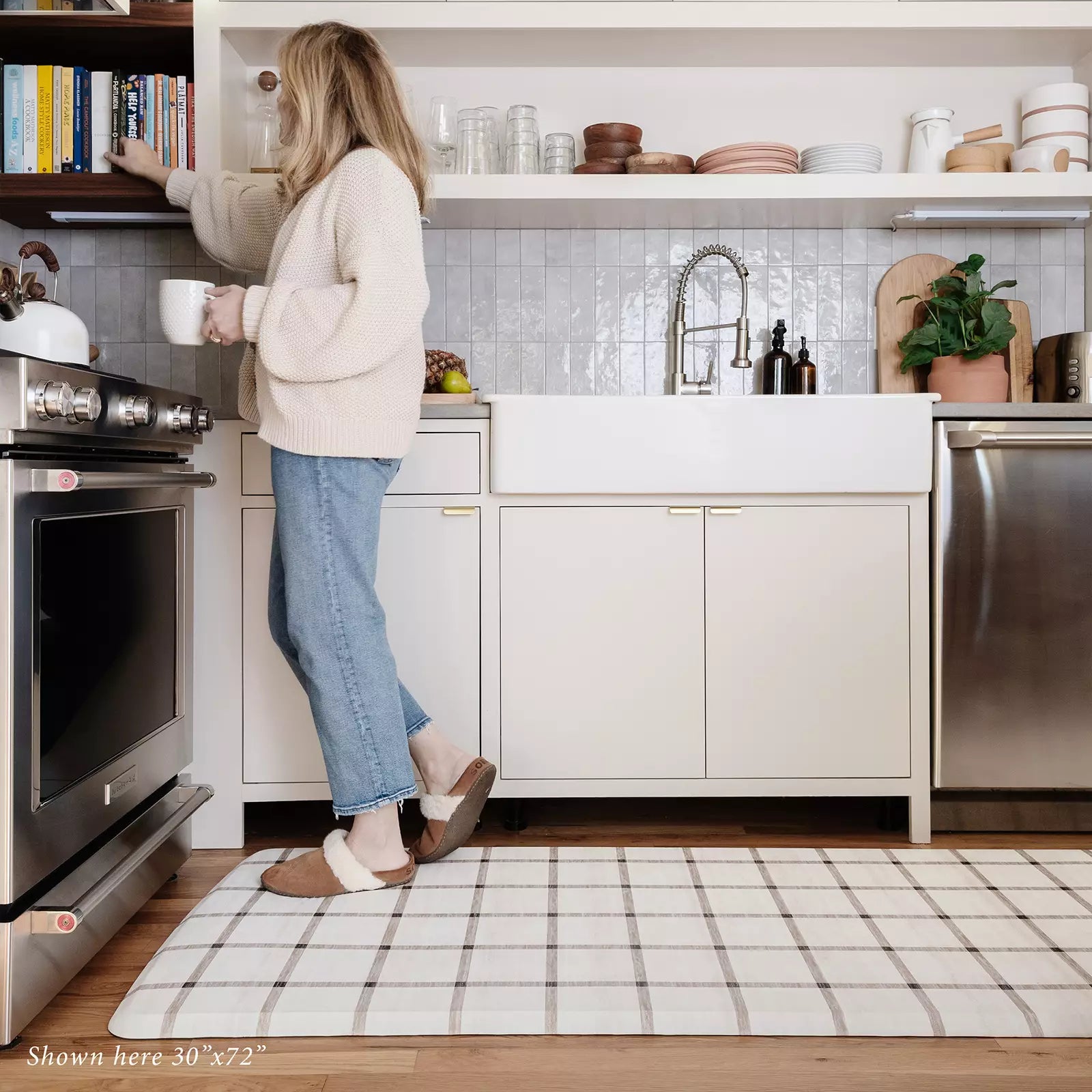 Windowpane Neutral Grid Pattern Standing Mat shown in kitchen with woman drinking coffee