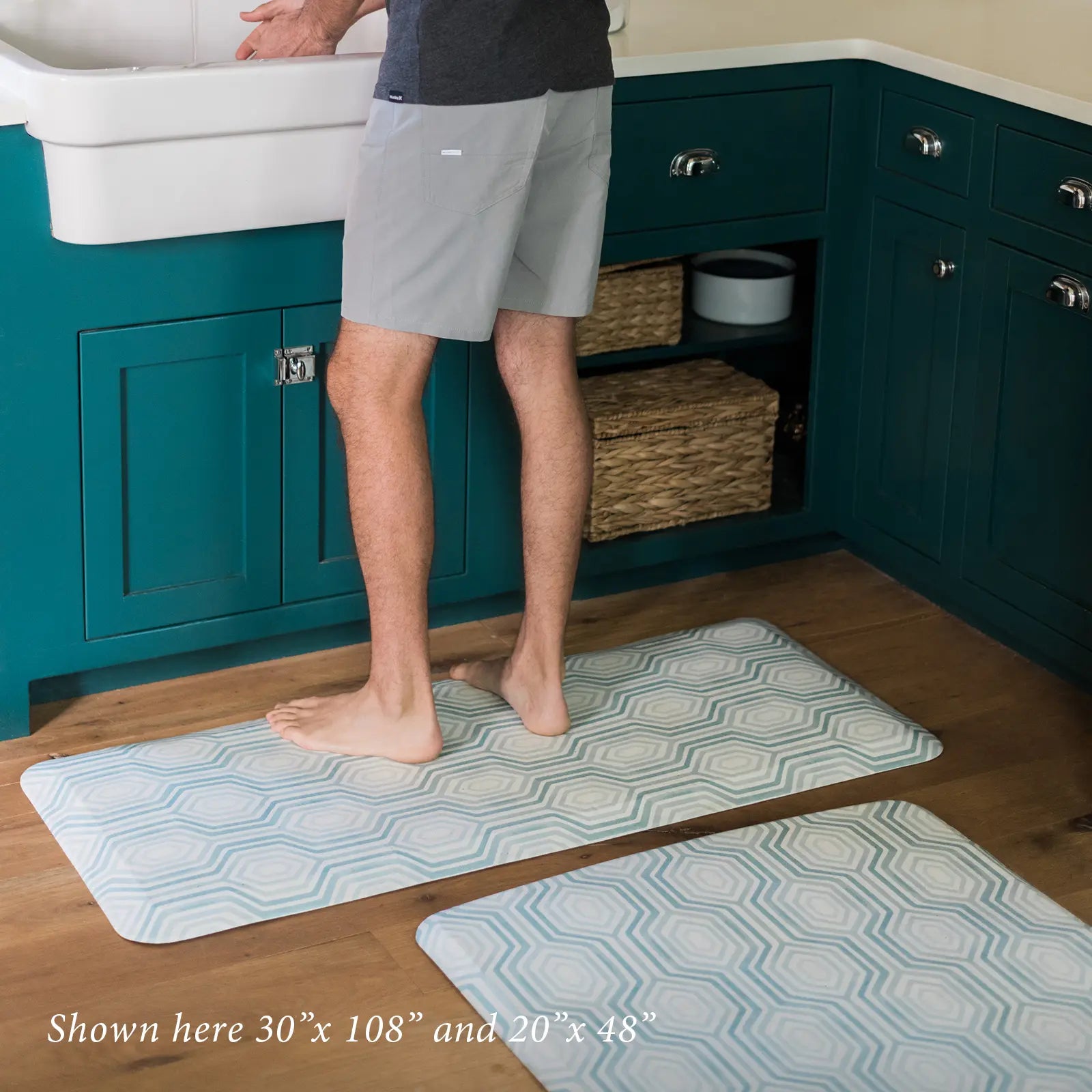 Blake waves blue and white mod preppy geometric print kitchen mat shown in sizes 30x108 and 20x48 in front of sink with man standing.