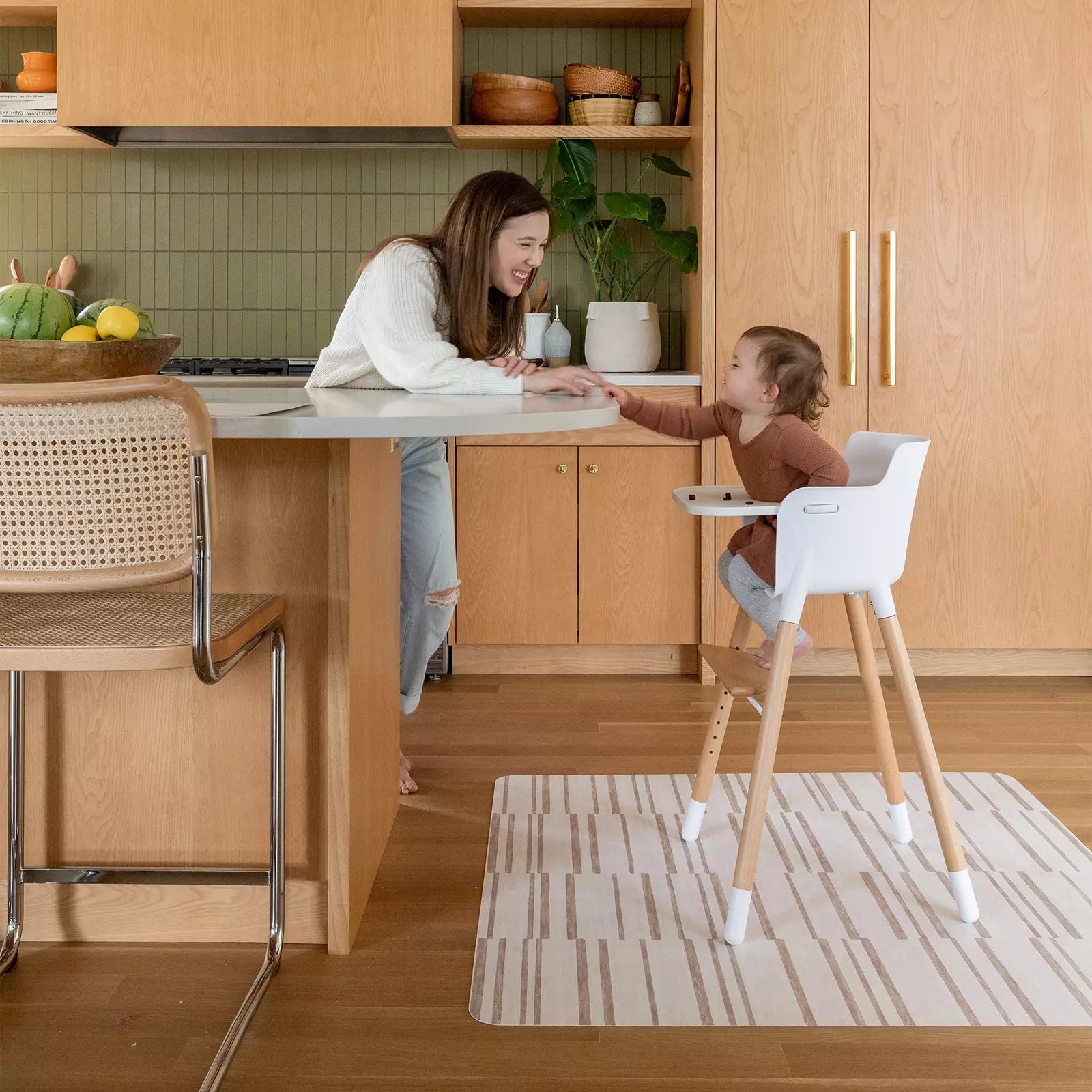 Nara Natural beige and cream striped highchair mat under high chair with mom feeding baby