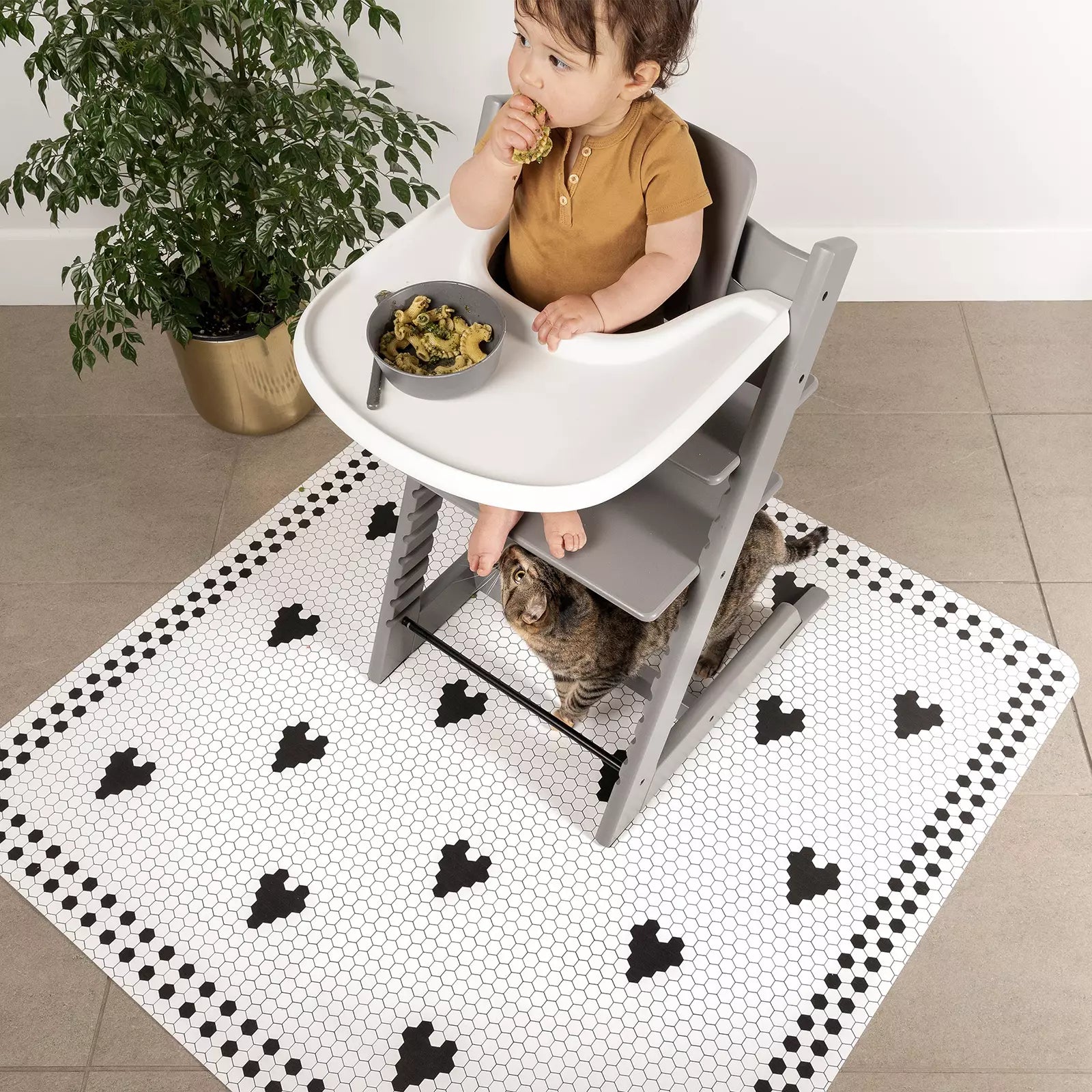 Penny Tile Black and White Heart pattern highchair mat under highchair with baby eating
