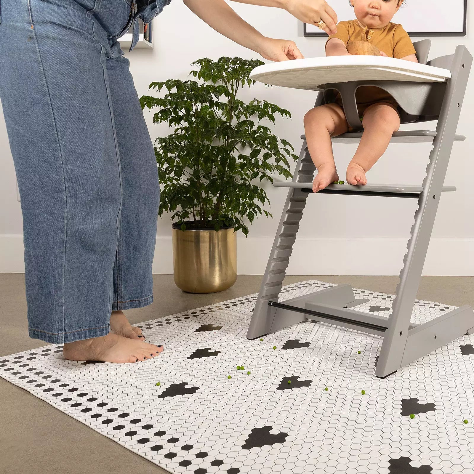 Penny Tile Black and White Heart pattern highchair mat under highchair with baby eating and mom