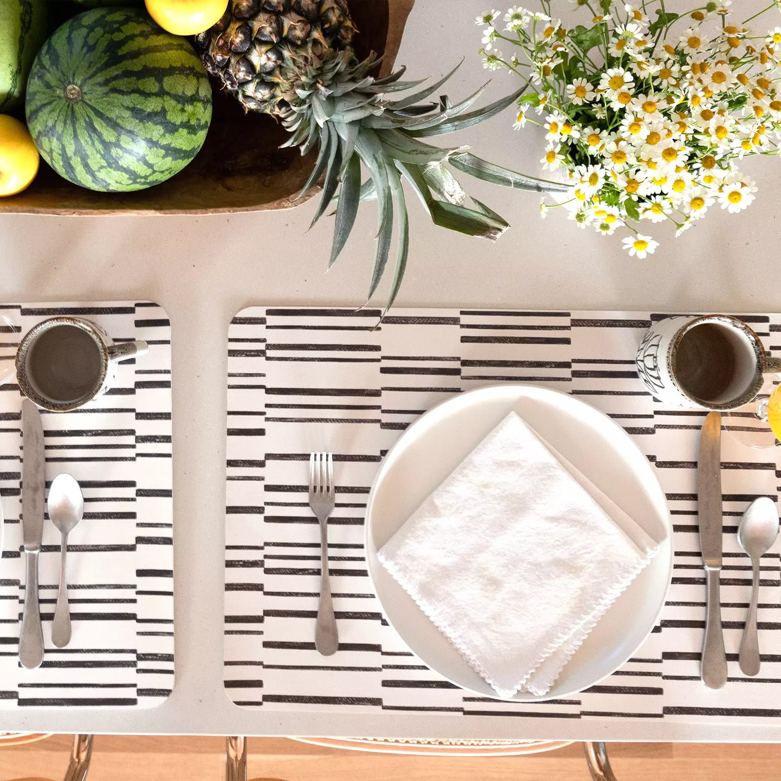 Nara Black and White Striped place mat at table setting with plate, napkin and silverware pictured from above